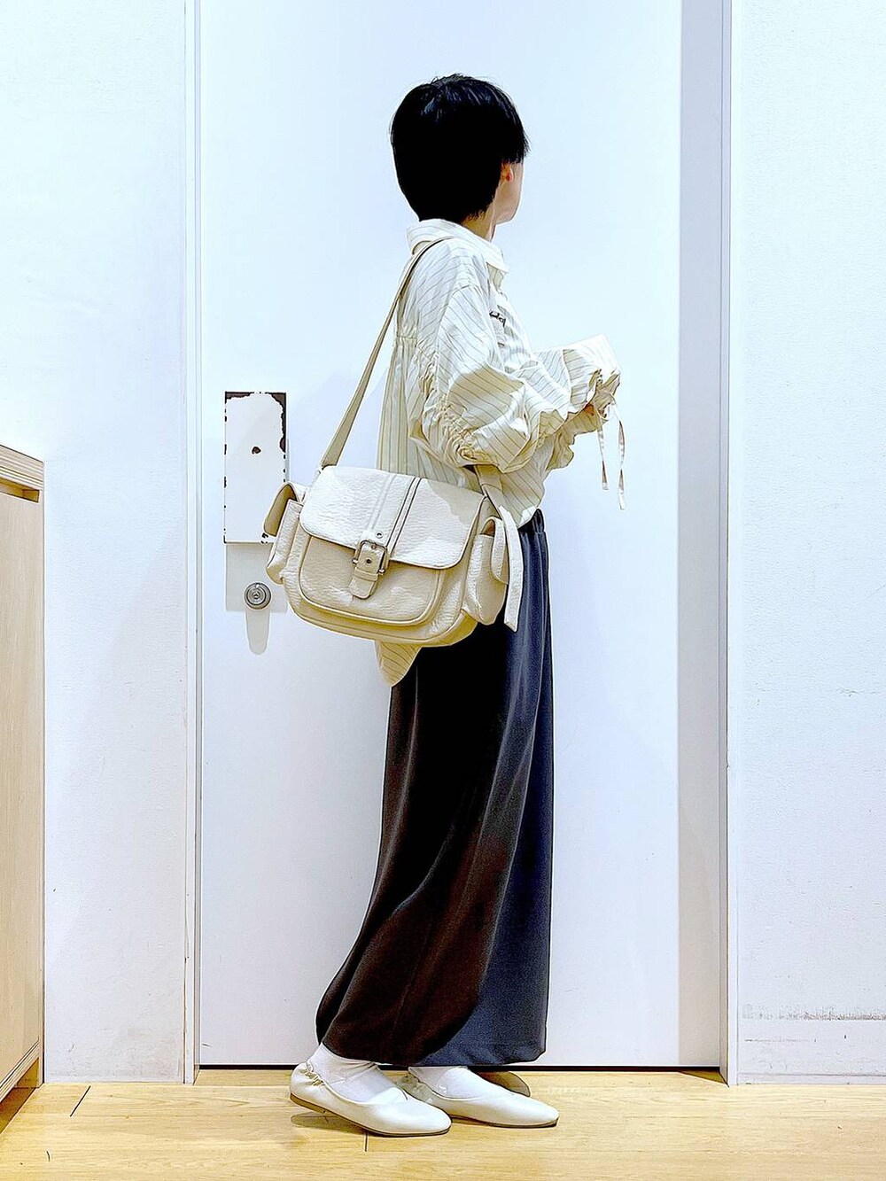 ホワイト系のパンプス、ベージュ系のシャツ/ブラウス、グレー系のスカートを着用したレディースの春コーディネートの4枚目の写真