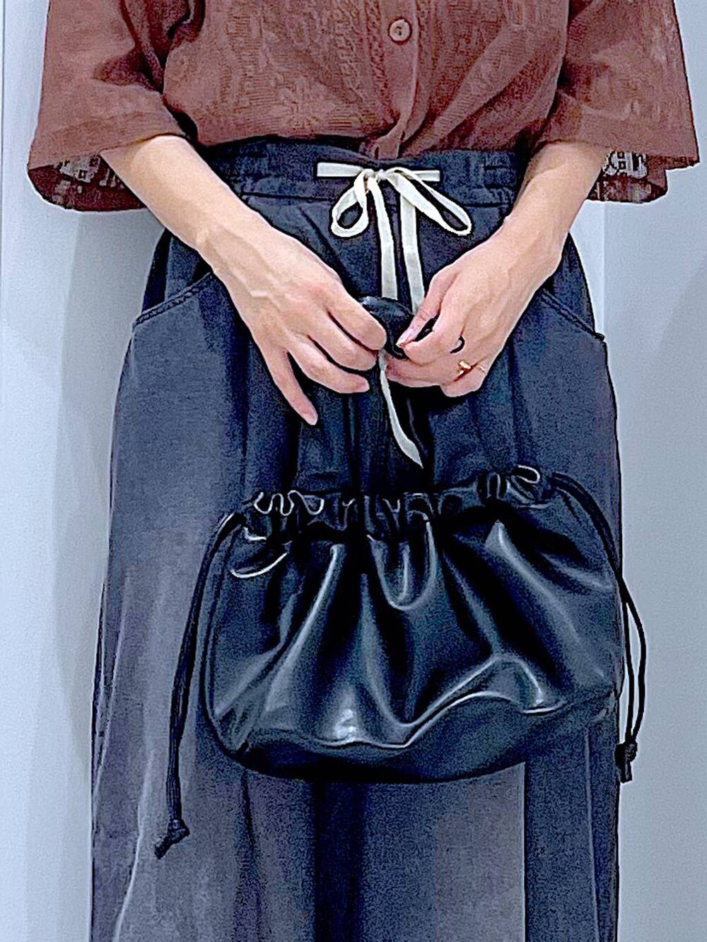 ブラウン系のシャツ/ブラウス、ブラック系のショルダーバッグ、ブラック系のデニムパンツを着用したレディースの夏コーディネートの9枚目の写真