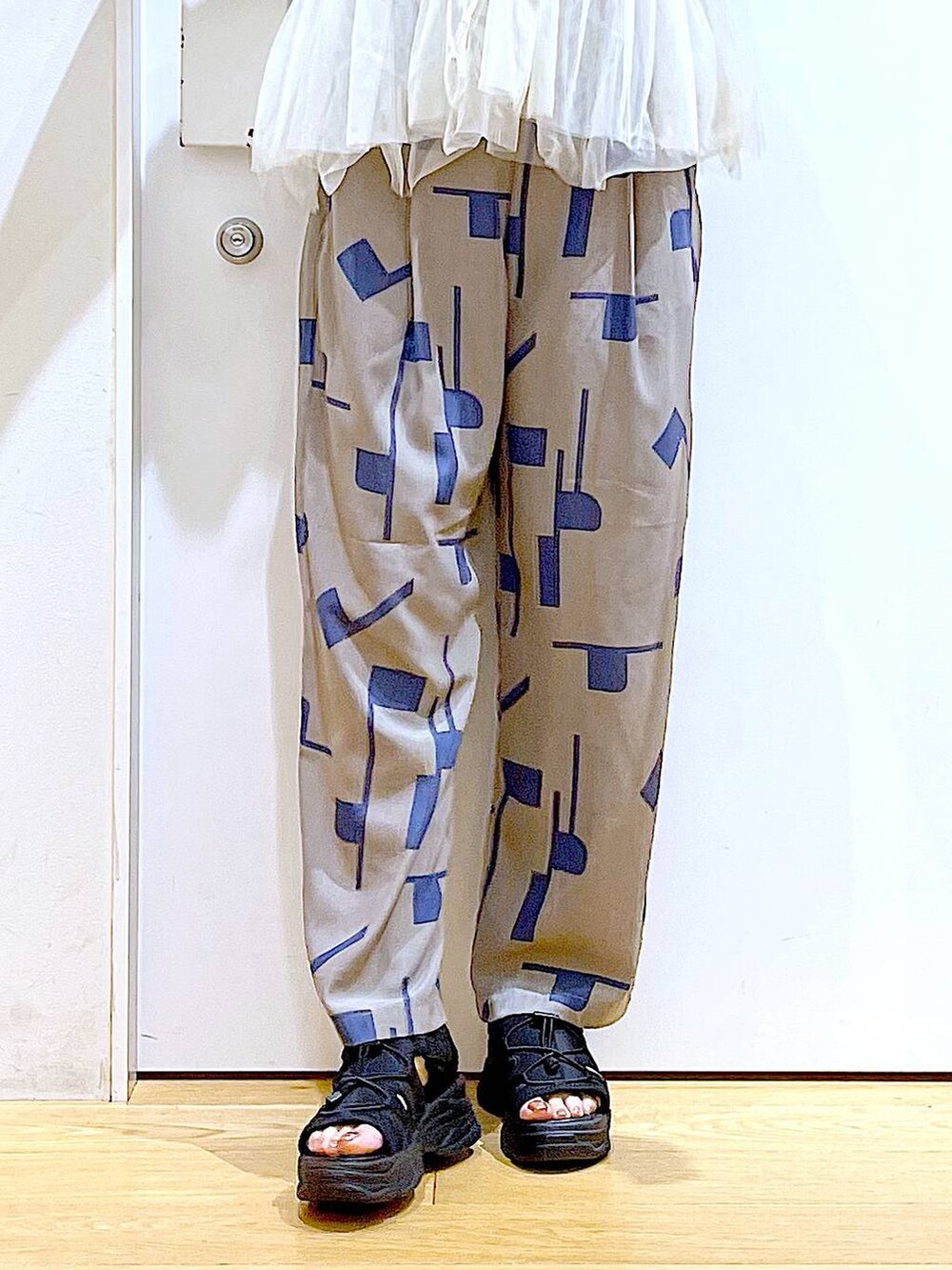 シルバー系のトートバッグ、グレー系のその他パンツ、ブラック系のサンダルを着用したレディースの夏コーディネートの8枚目の写真