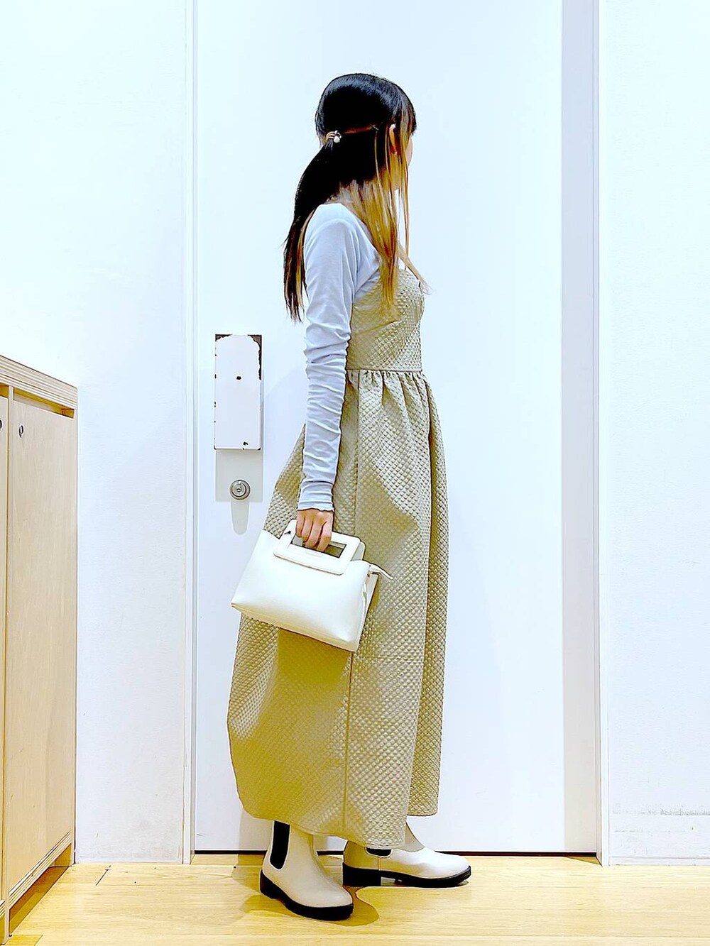 ブルー系のTシャツ/カットソー、ブラウン系のワンピース、ベージュ系のブーツを着用したレディースの冬コーディネートの4枚目の写真