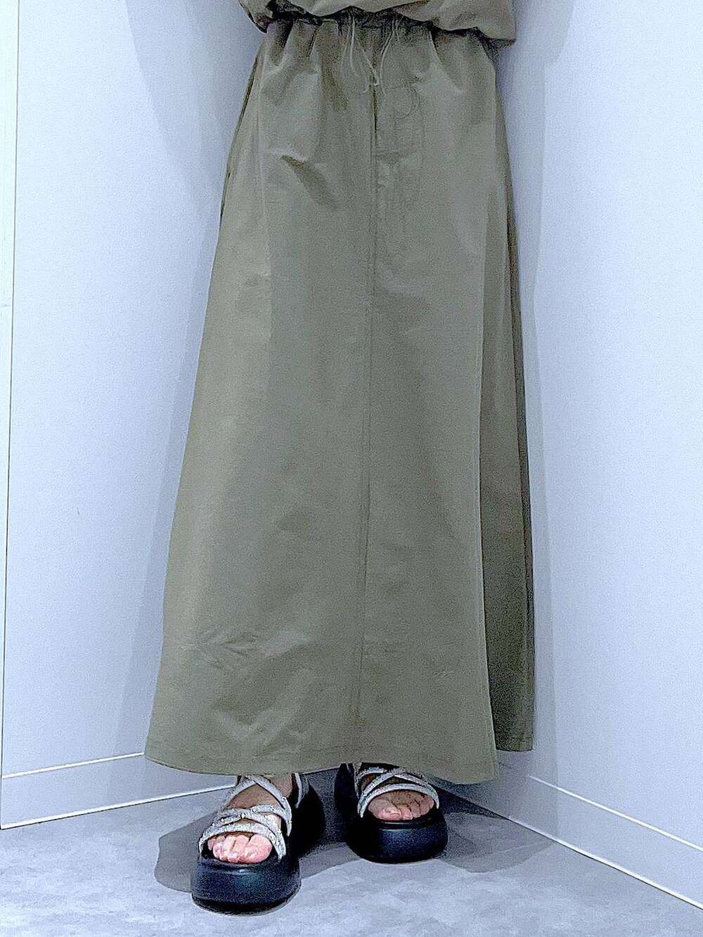 ブラック系のショルダーバッグ、シルバー系のサンダル、グリーン系のTシャツ/カットソーを着用したレディースの夏コーディネートの8枚目の写真