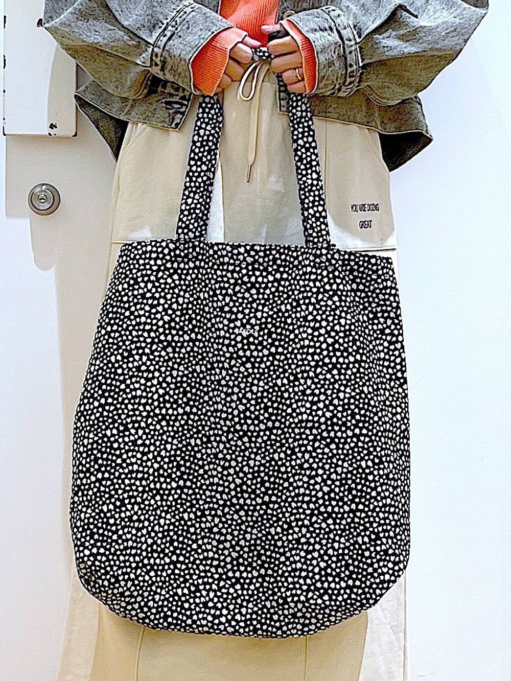 ブラック系のブーツ、その他のトートバッグ、ブラック系のデニムジャケットを着用したレディースの春コーディネートの9枚目の写真