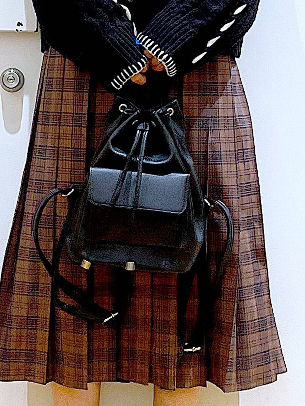 ブラック系のニット/セーター、ブラック系のバックパック/リュック、ブラック系のブーツを着用したレディースの冬コーディネートの9枚目の写真