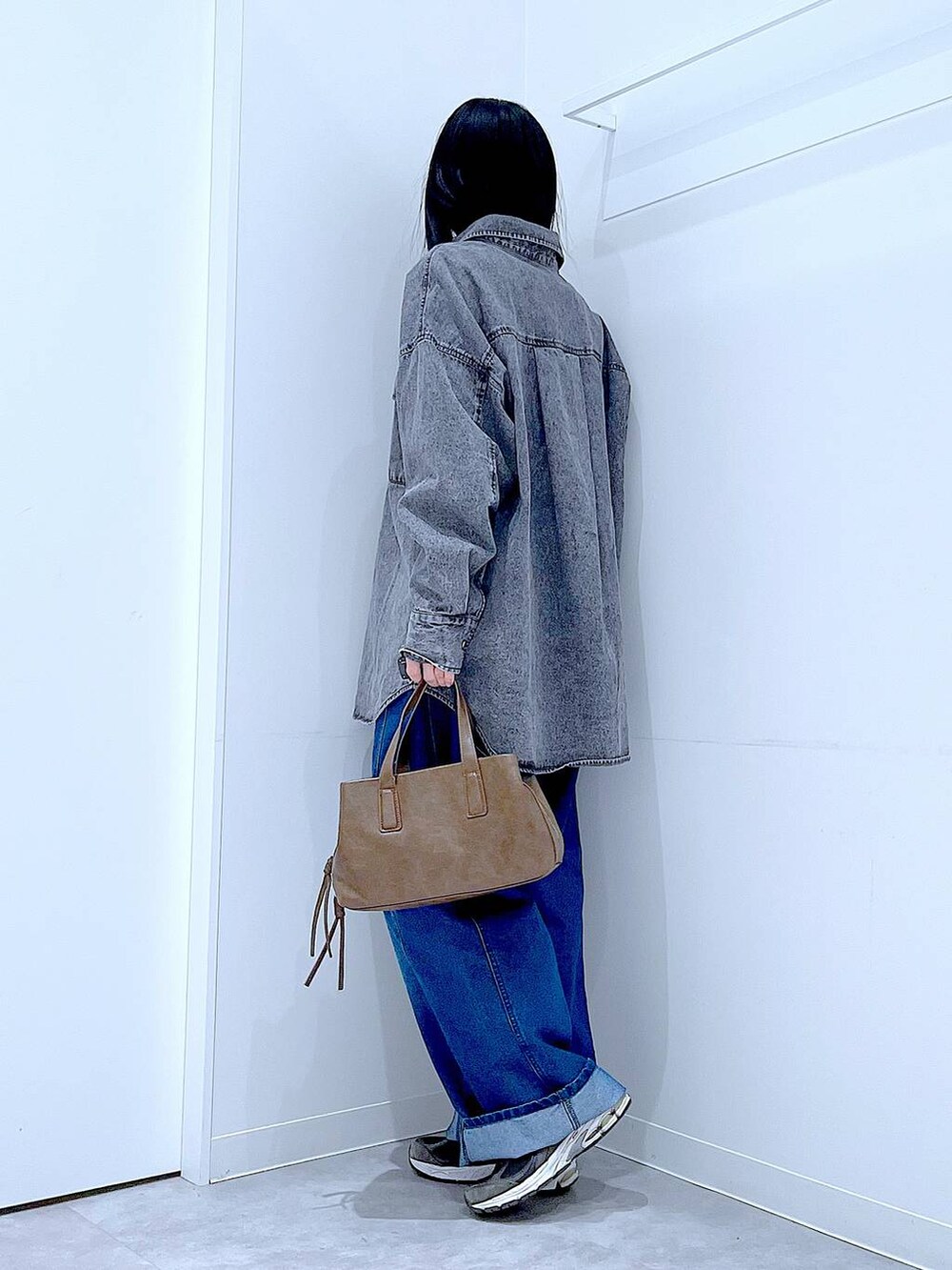 ブラウン系のボストンバッグ、ブルー系のデニムパンツ、ブラック系のシャツ/ブラウスを着用したレディースの冬コーディネートの3枚目の写真