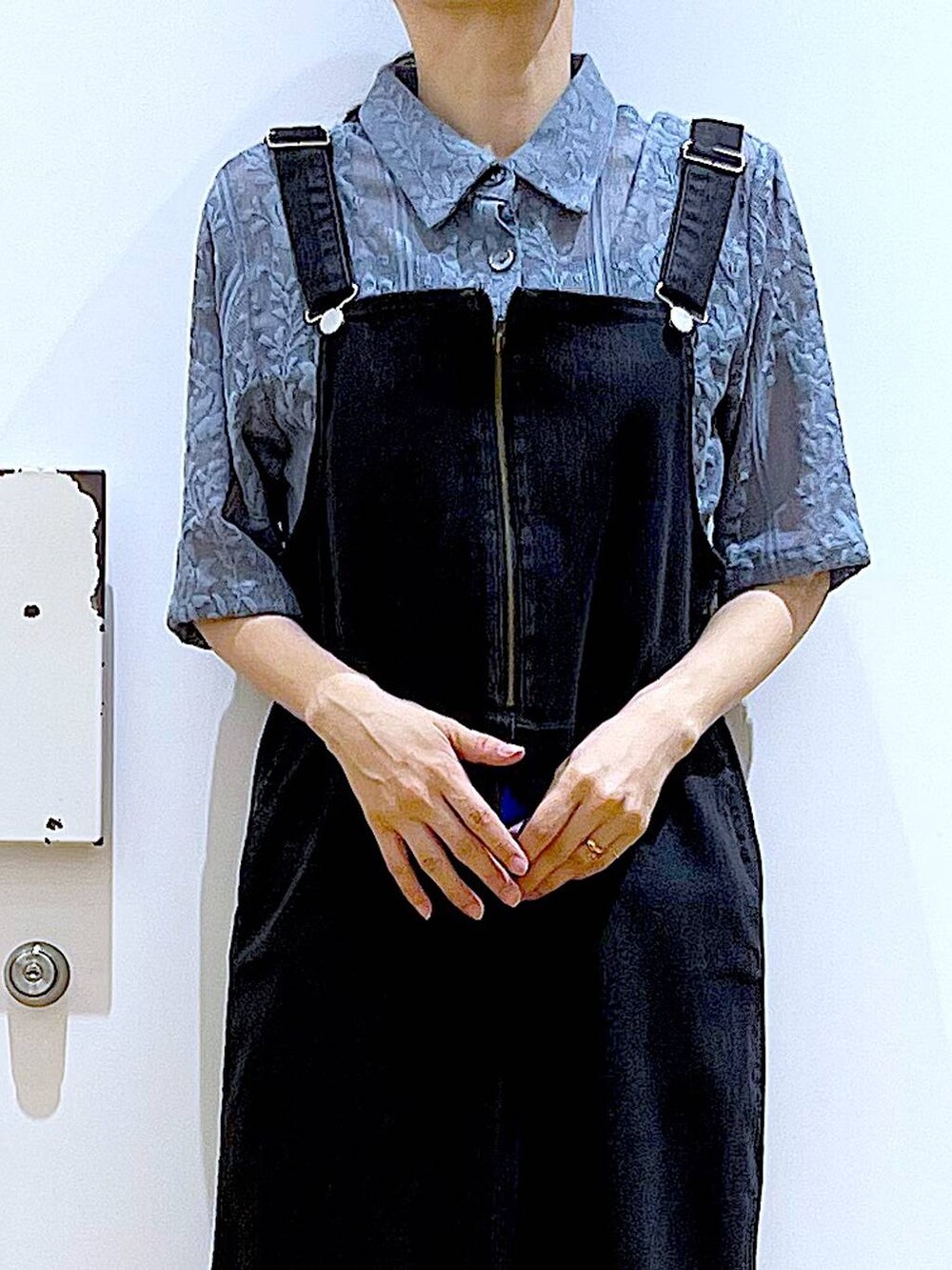 グレー系のジャンパースカート、ブラック系のパンプス、ベージュ系のショルダーバッグを着用したレディースの夏コーディネートの7枚目の写真