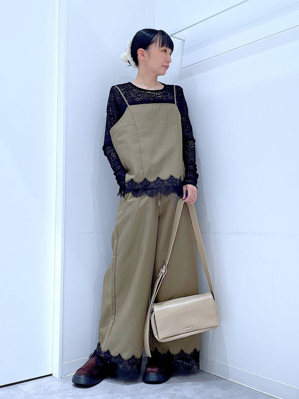 イエロー系のスラックス、イエロー系のキャミソール、ブラック系のTシャツ/カットソーを着用したレディースの秋コーディネートの2枚目の写真