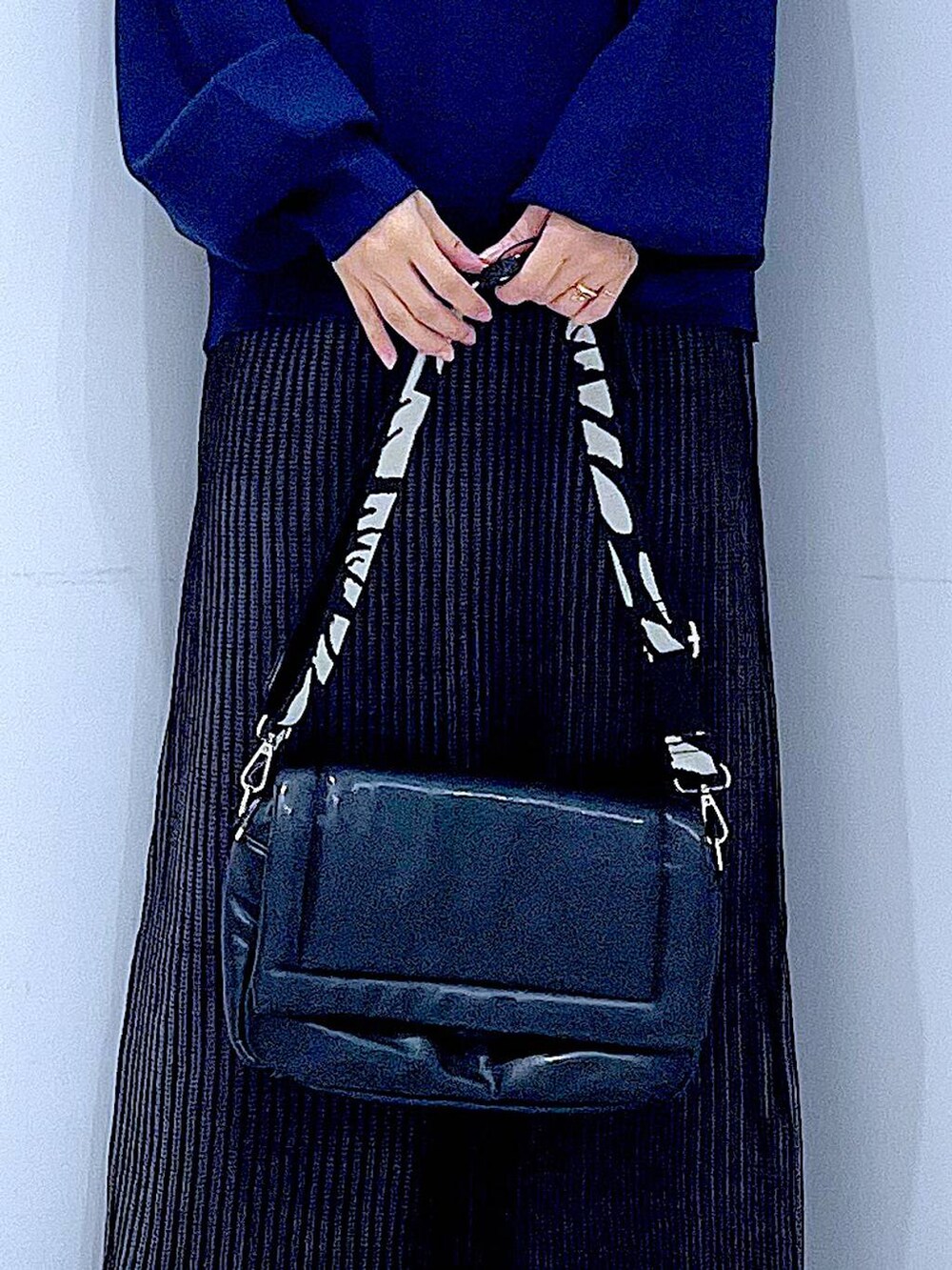 ブラック系のスカート、ブラック系のショルダーバッグ、ブラック系のブーツを着用したレディースの冬コーディネートの9枚目の写真