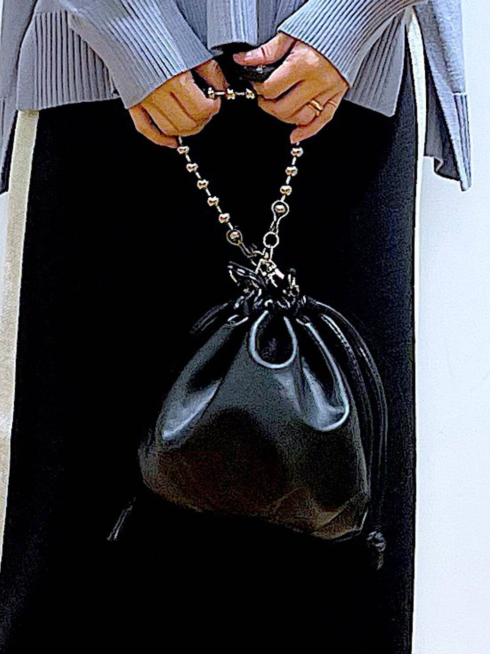 ブラック系のスカート、ブラック系のショルダーバッグ、ブラック系のブーツを着用したレディースの冬コーディネートの9枚目の写真