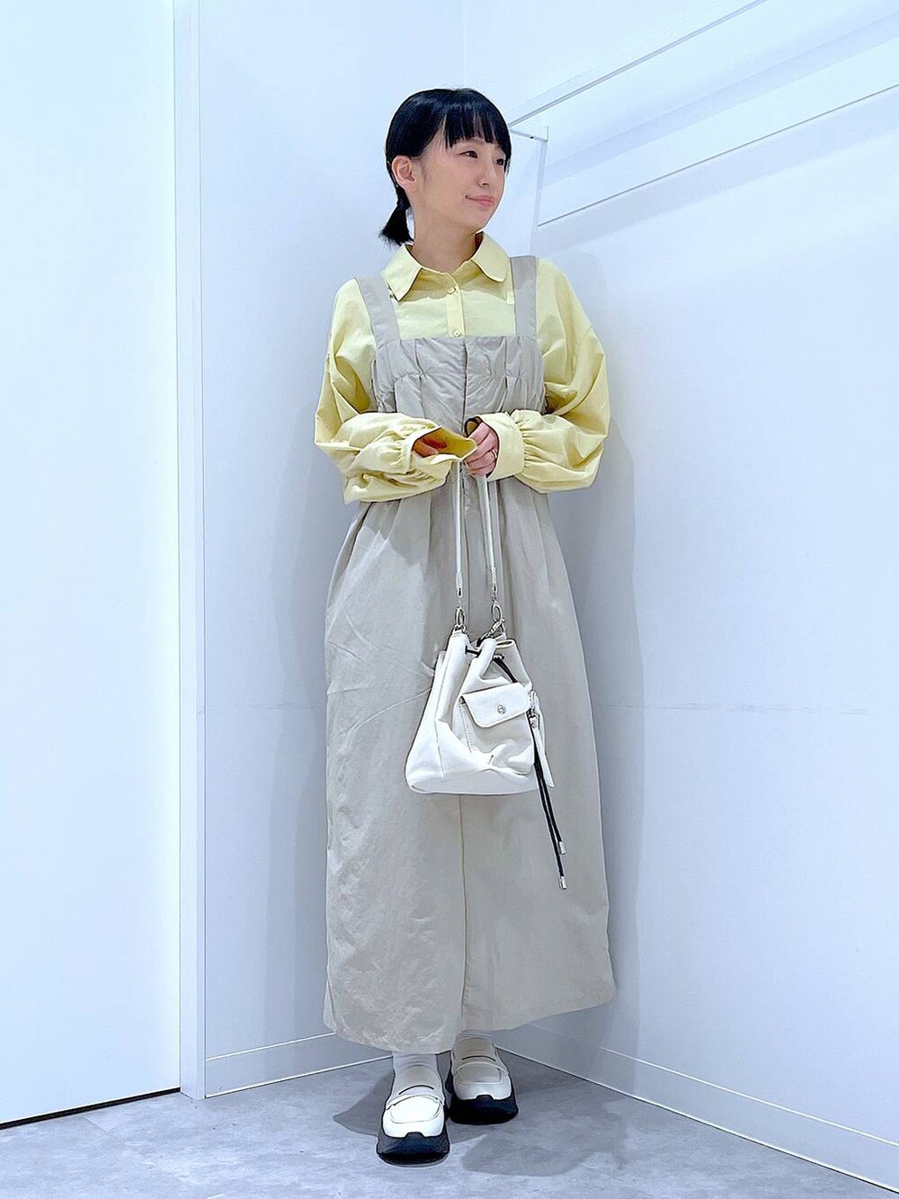 ホワイト系のローファー、ホワイト系のショルダーバッグ、グレー系のワンピースを着用したレディースの秋コーディネートの2枚目の写真