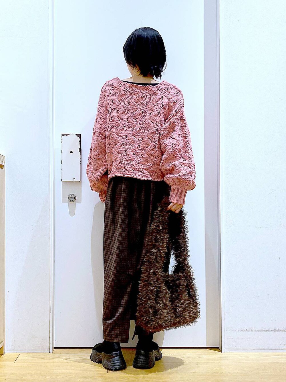 ブラック系のブーツ、ブラウン系のショルダーバッグ、ピンク系のニット/セーターを着用したレディースの冬コーディネートの5枚目の写真