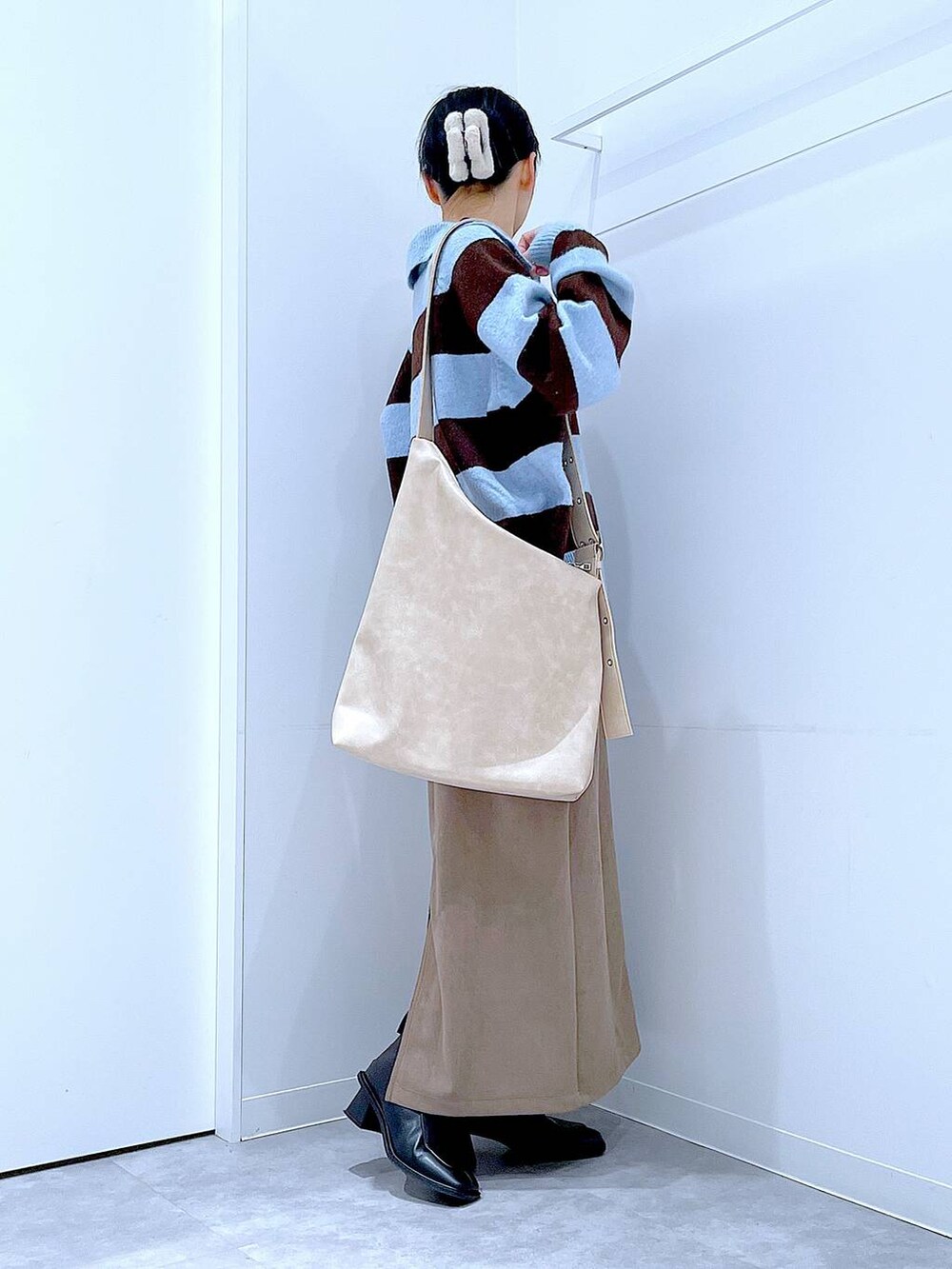 ブラック系のブーツ、ブラウン系のスカート、ブルー系のニット/セーターを着用したレディースの冬コーディネートの4枚目の写真