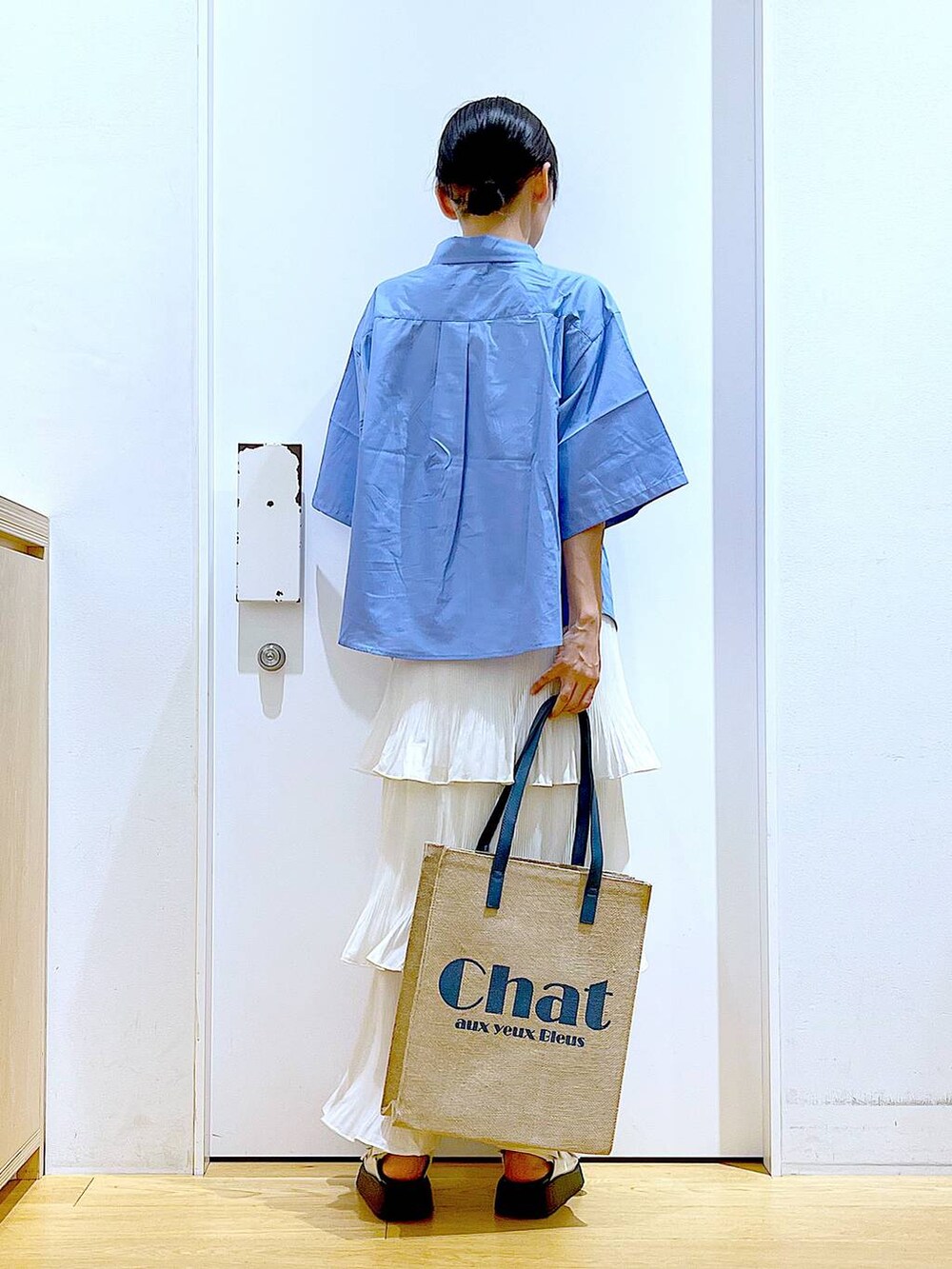 ベージュ系のスカート、ブルー系のトートバッグ、ホワイト系のサンダルを着用したレディースの夏コーディネートの5枚目の写真