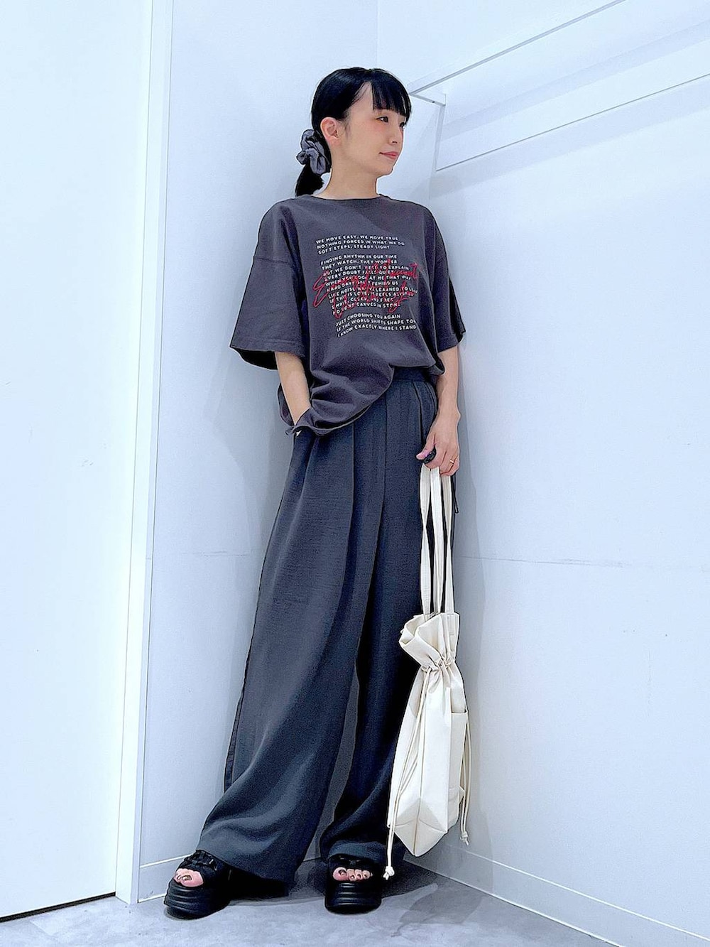 ブラック系のサンダル、グレー系のその他パンツ、ホワイト系のトートバッグを着用したレディースの夏コーディネートの2枚目の写真