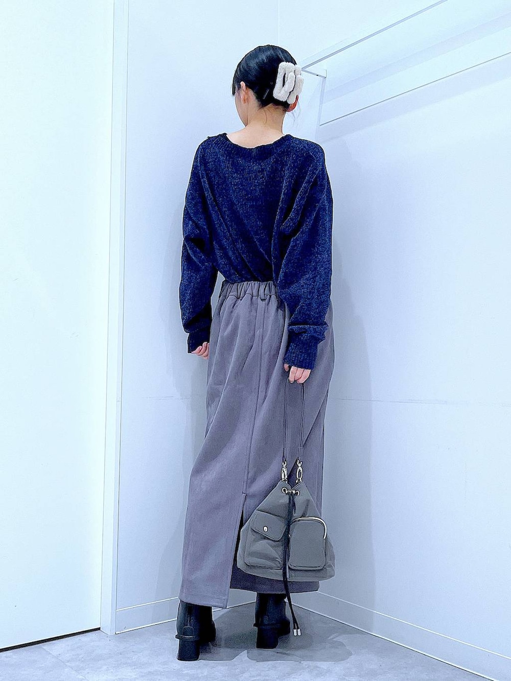 ブラック系のブーツ、ブルー系のニット/セーター、グレー系のスカートを着用したレディースの冬コーディネートの5枚目の写真