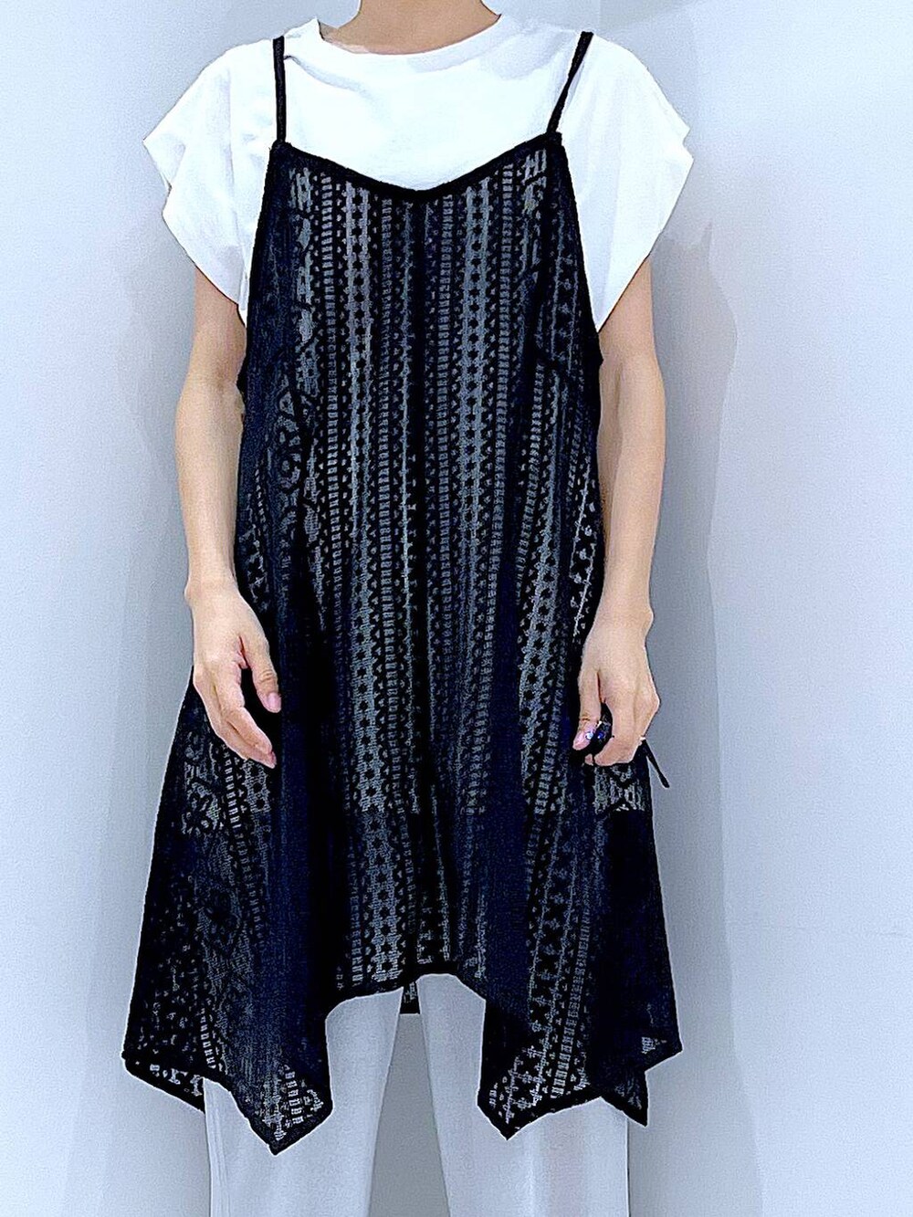 ブラック系のショルダーバッグ、ブラック系のサンダル、ホワイト系のTシャツ/カットソーを着用したレディースの夏コーディネートの7枚目の写真