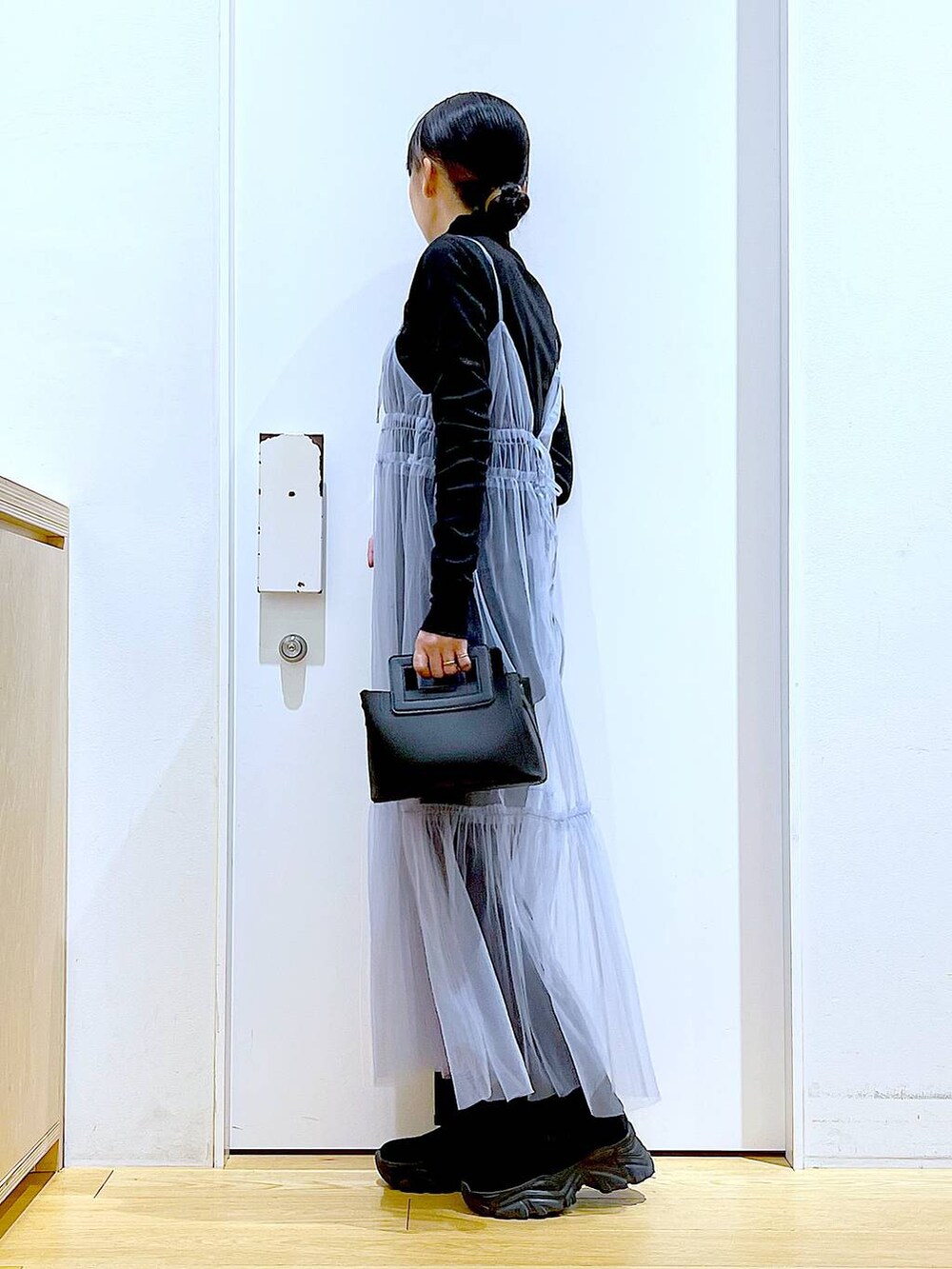 グレー系のデニムパンツ、ブルー系のワンピース、ブラック系のTシャツ/カットソーを着用したレディースの春コーディネートの3枚目の写真