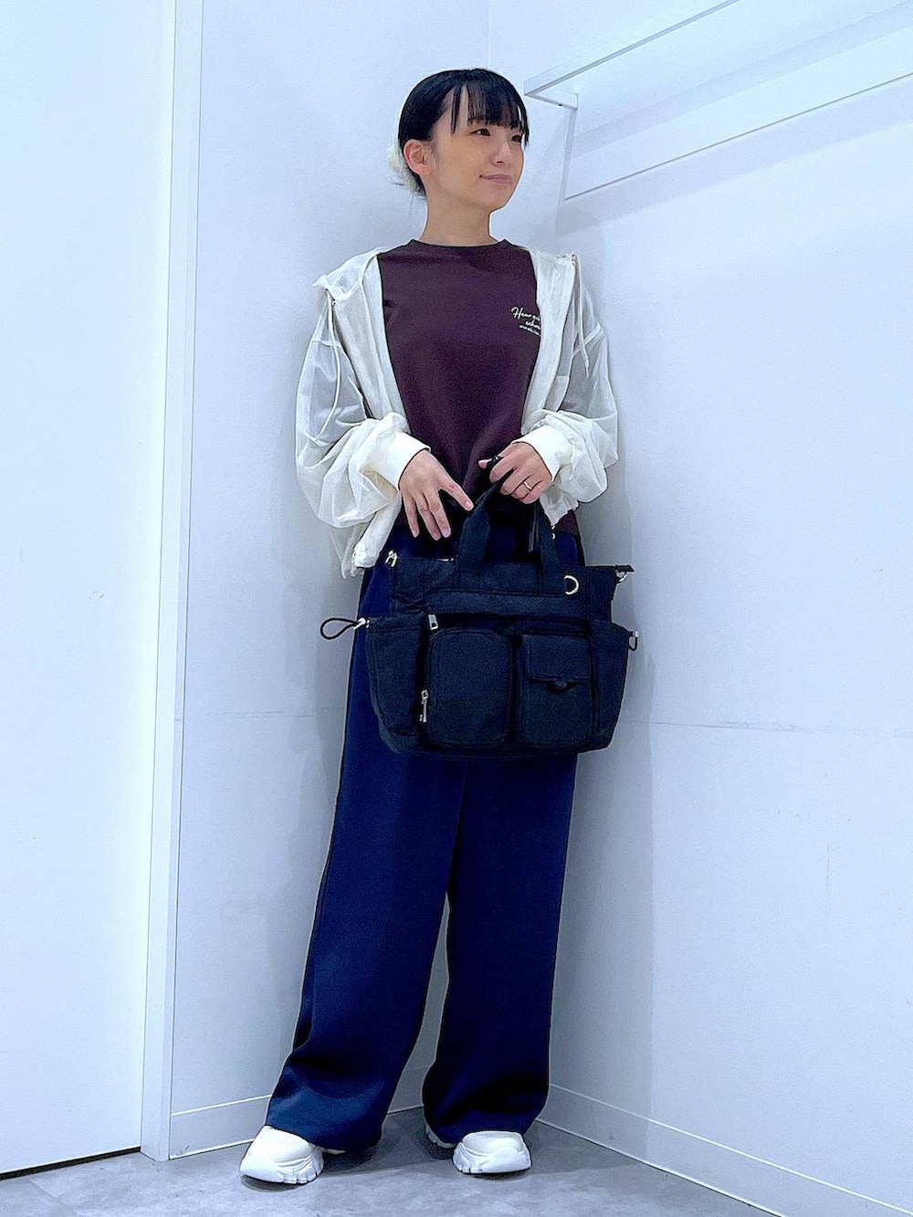 ブラック系のトートバッグ、ブルー系のその他パンツ、ホワイト系のスニーカーを着用したレディースの春コーディネートの2枚目の写真