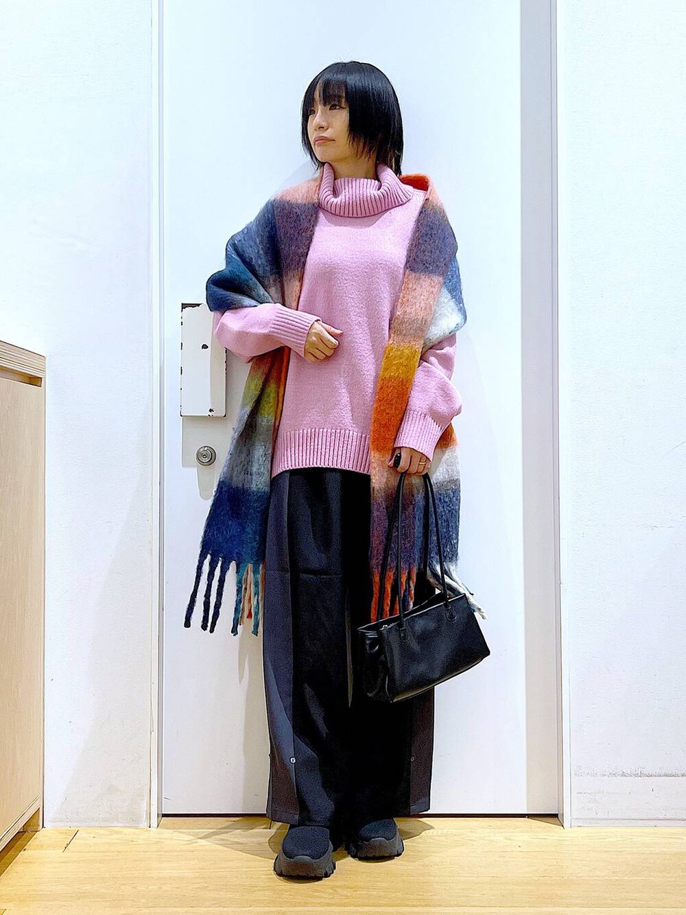 ブラック系のトートバッグ、ブラック系のブーツ、ブラック系のその他パンツを着用したレディースの冬コーディネートの2枚目の写真