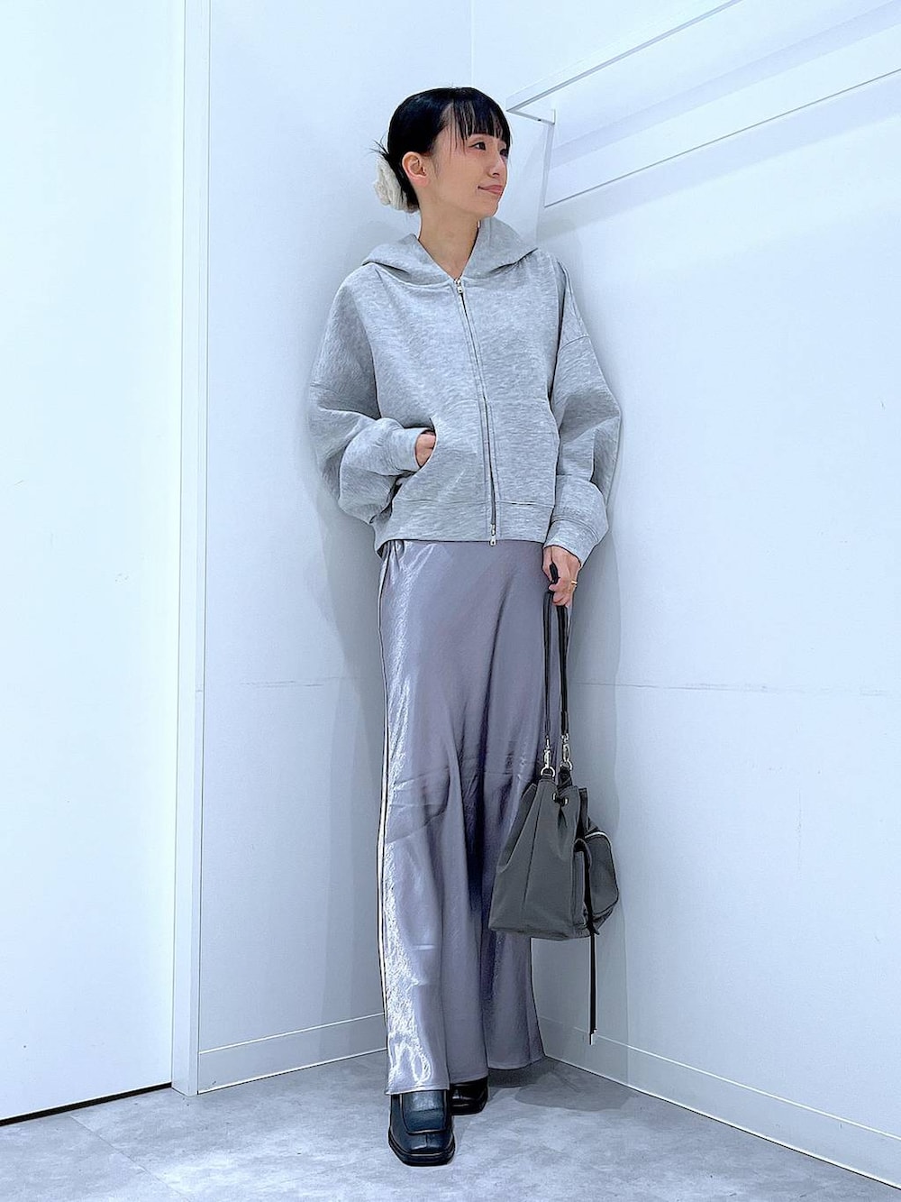 ブラック系のブーツ、グレー系のスカート、グレー系のパーカーを着用したレディースの春コーディネートの2枚目の写真