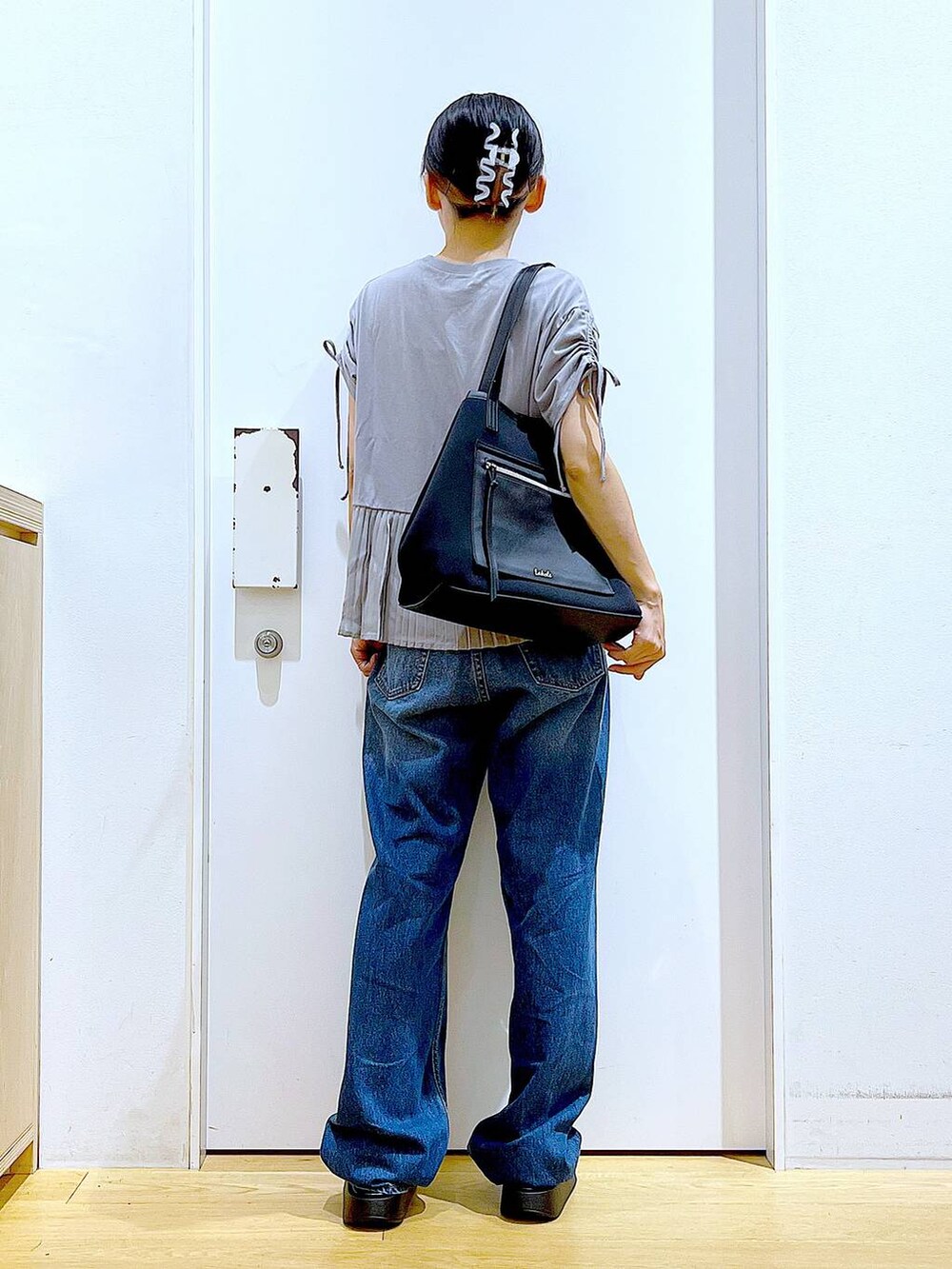 ホワイト系のサンダル、ブラック系のトートバッグ、ブルー系のデニムパンツを着用したレディースの夏コーディネートの5枚目の写真