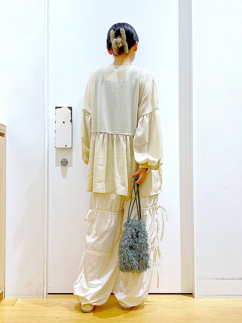 グリーン系のショルダーバッグ、ホワイト系のパンプス、ホワイト系のその他パンツを着用したレディースの秋コーディネートの5枚目の写真