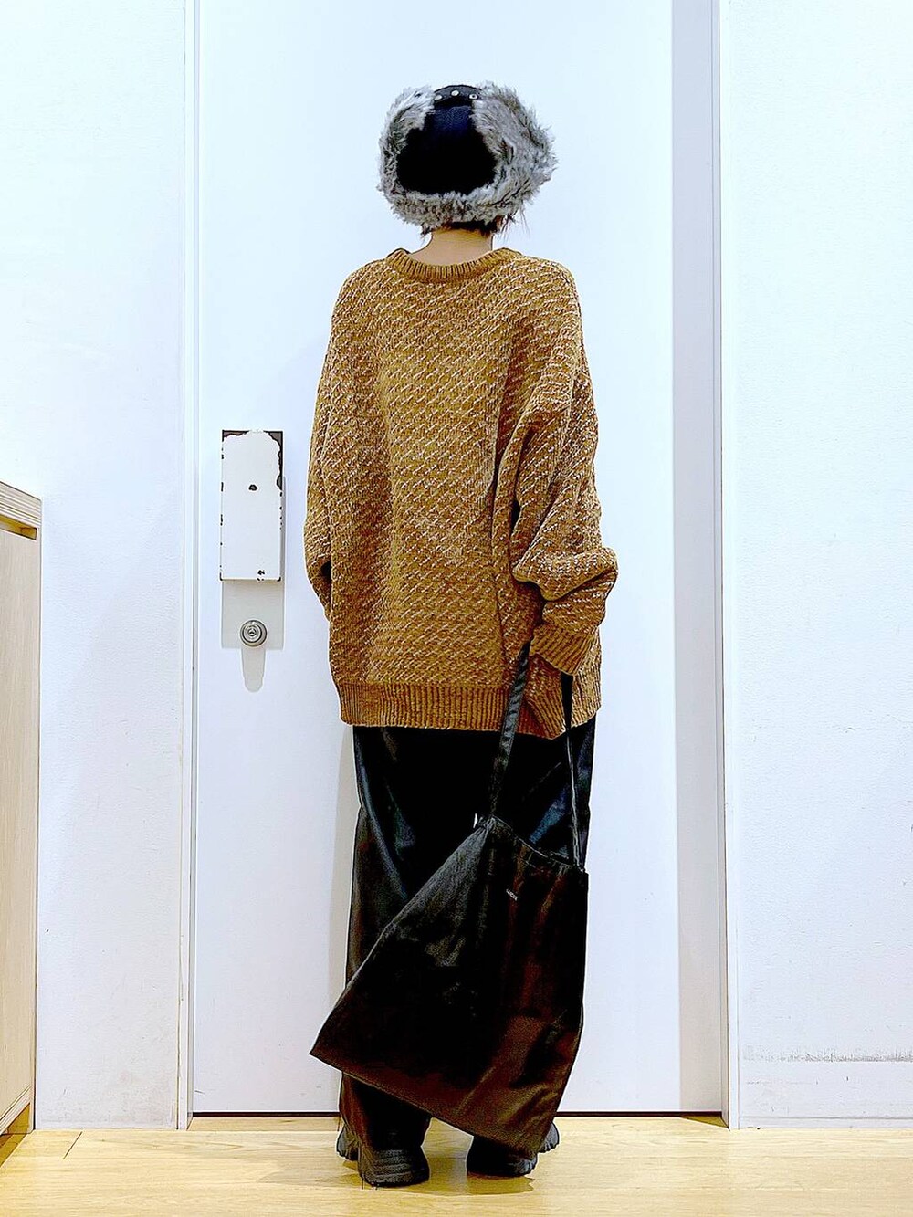 ブラック系のトートバッグ、ブラック系のブーツ、ブラック系のその他パンツを着用したレディースの冬コーディネートの5枚目の写真