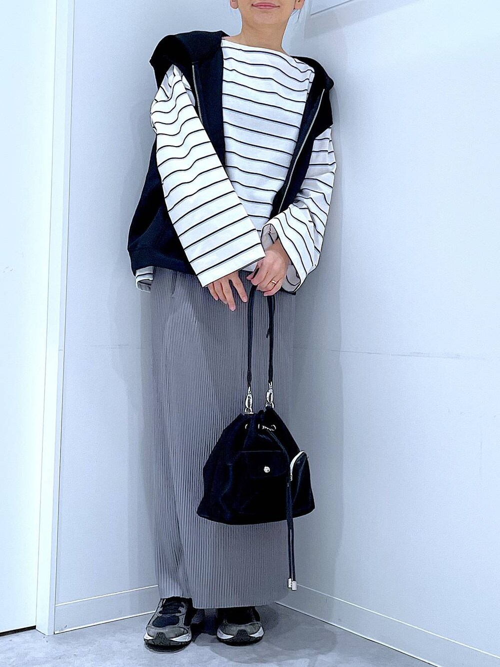 ブラック系のショルダーバッグ、ホワイト系のTシャツ/カットソー、グレー系のスカートを着用したレディースの春コーディネートの6枚目の写真