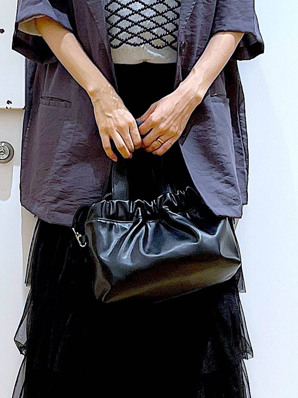 ブラック系のサンダル、ブラック系のショルダーバッグ、ブラック系のスカートを着用したレディースの夏コーディネートの9枚目の写真