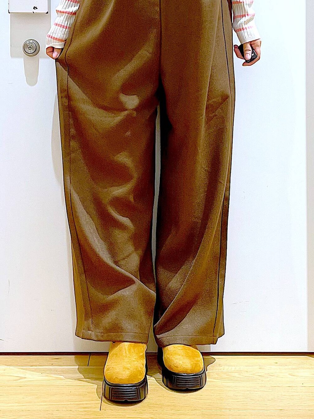 ピンク系のニット/セーター、ブラック系のショルダーバッグ、ベージュ系のブーツを着用したレディースの冬コーディネートの8枚目の写真