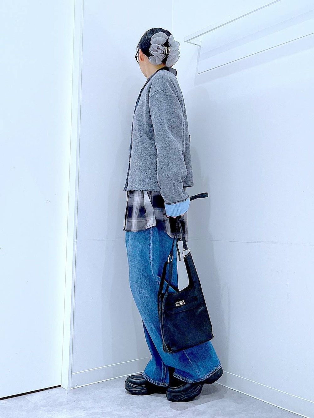ブルー系のデニムパンツ、ブラック系のシャツ/ブラウス、ブラック系のショルダーバッグを着用したレディースの秋コーディネートの3枚目の写真