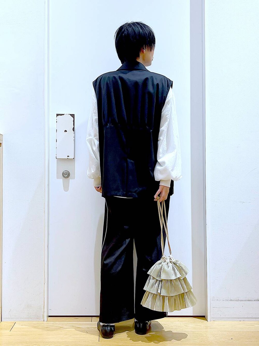 ブラック系のスラックス、ブラック系のパンプス、ホワイト系のスウェットを着用したレディースの春コーディネートの5枚目の写真