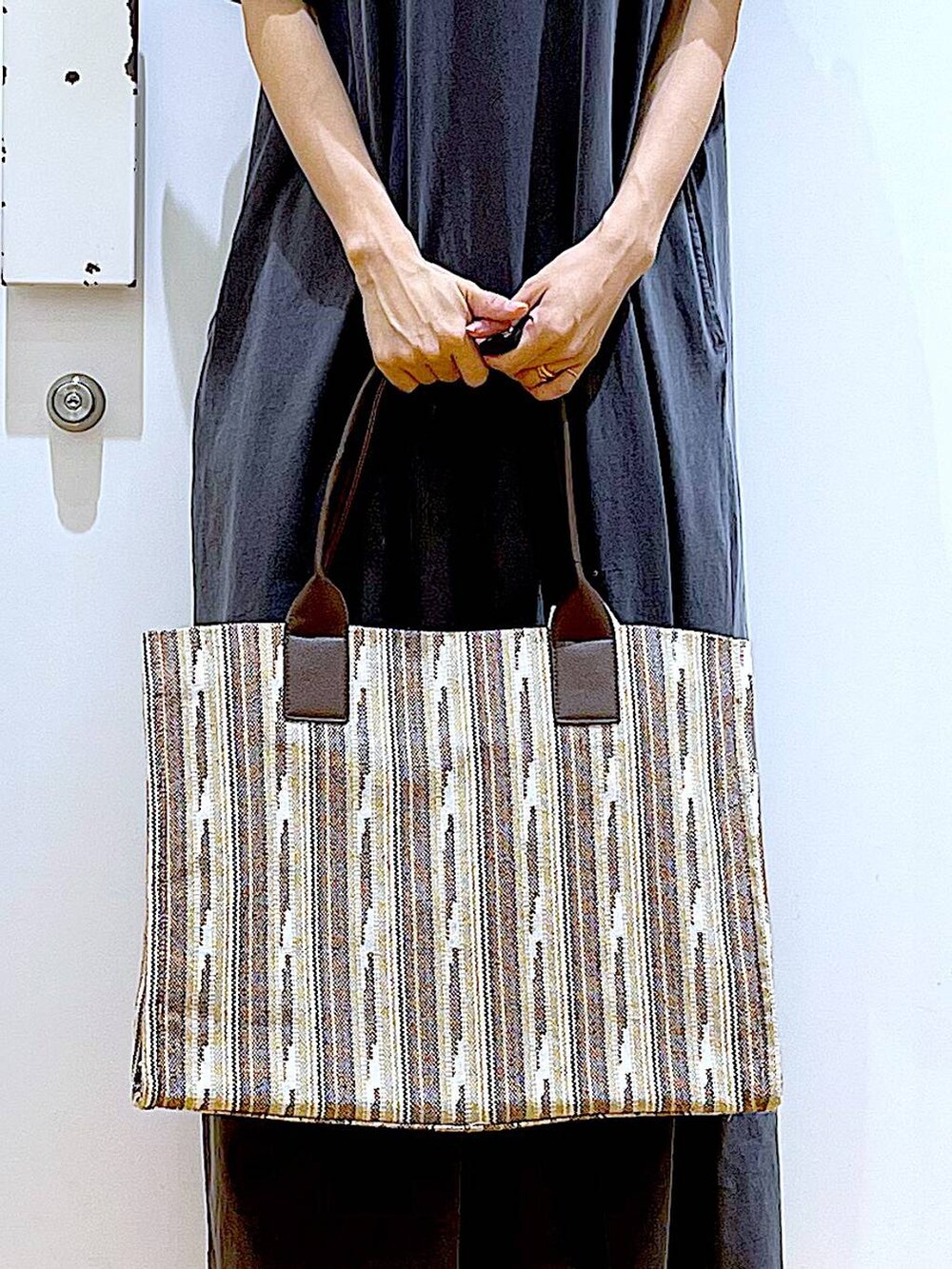 ホワイト系のサンダル、ブラウン系のトートバッグ、グレー系のワンピースを着用したレディースの夏コーディネートの9枚目の写真