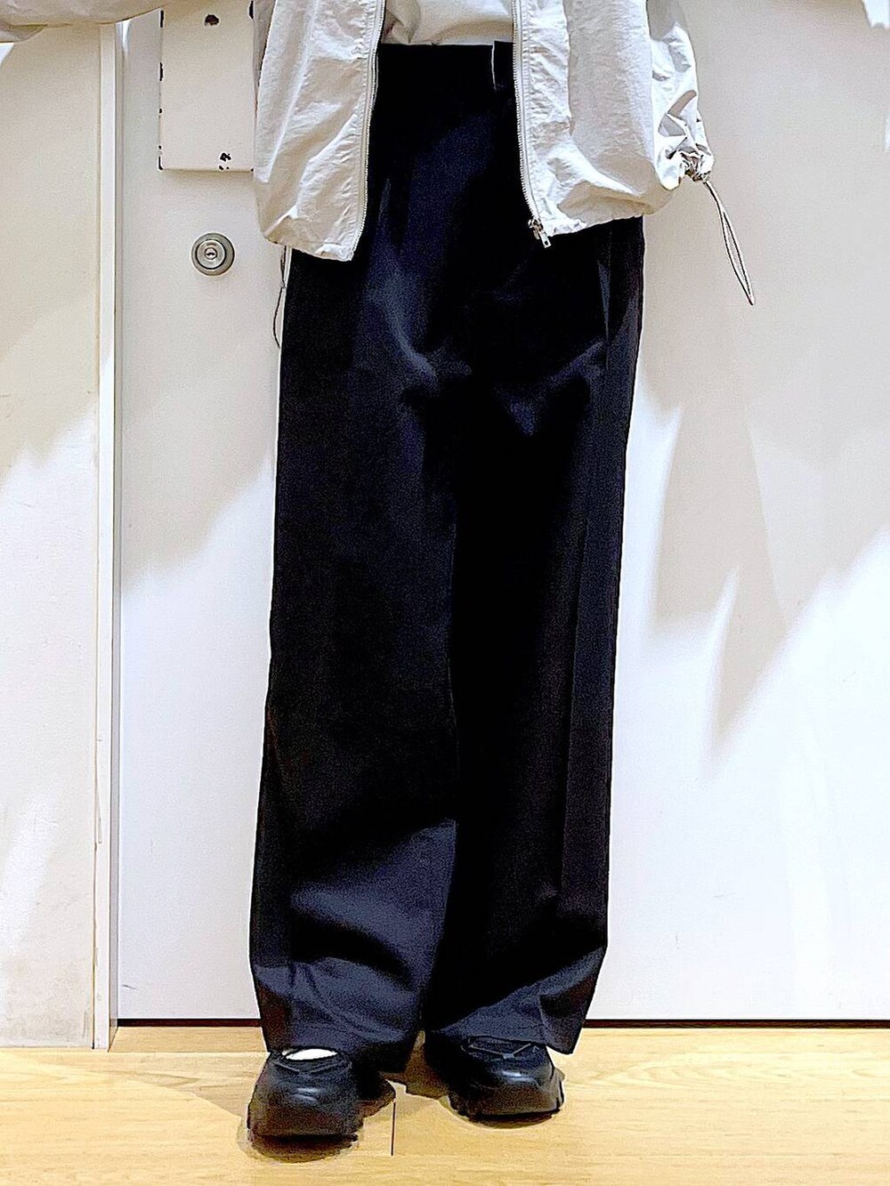 ブラック系のスラックス、ブラック系のスニーカー、ブラック系のショルダーバッグを着用したレディースの春コーディネートの8枚目の写真