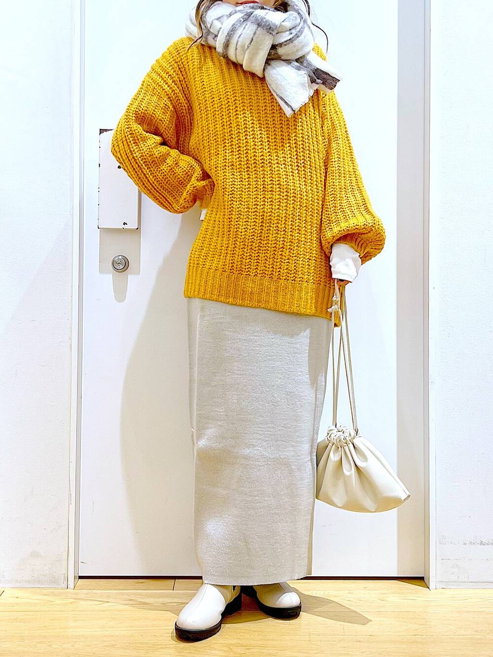 グレー系のスカート、ベージュ系のブーツ、ベージュ系のショルダーバッグを着用したレディースの冬コーディネートの6枚目の写真