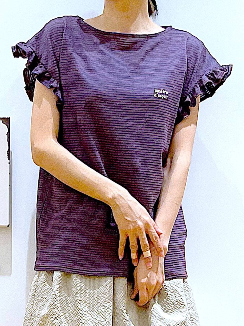 ブラウン系のTシャツ/カットソー、ベージュ系のスカート、ブラック系のバックパック/リュックを着用したレディースの春コーディネートの7枚目の写真