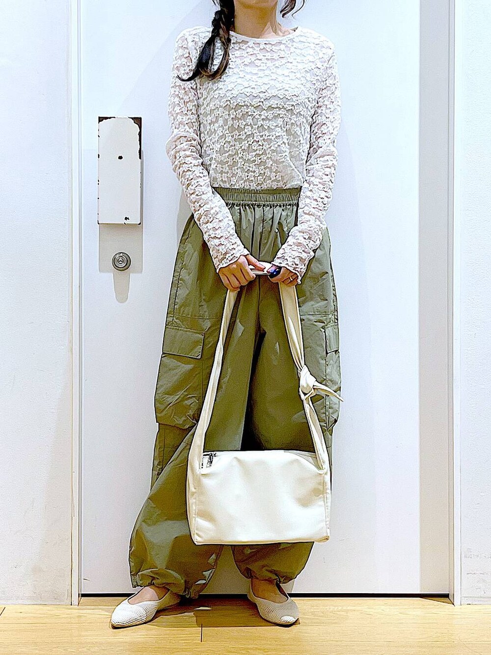 グリーン系のカーゴパンツ、ホワイト系のショルダーバッグ、ホワイト系のパンプスを着用したレディースの春コーディネートの6枚目の写真