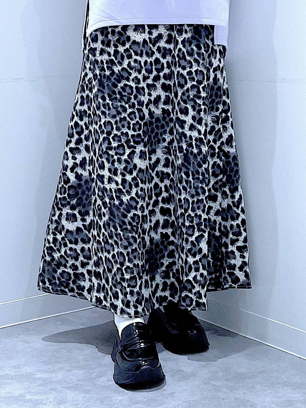 ホワイト系のショルダーバッグ、ブラック系のローファー、グレー系のスカートを着用したレディースの秋コーディネートの8枚目の写真