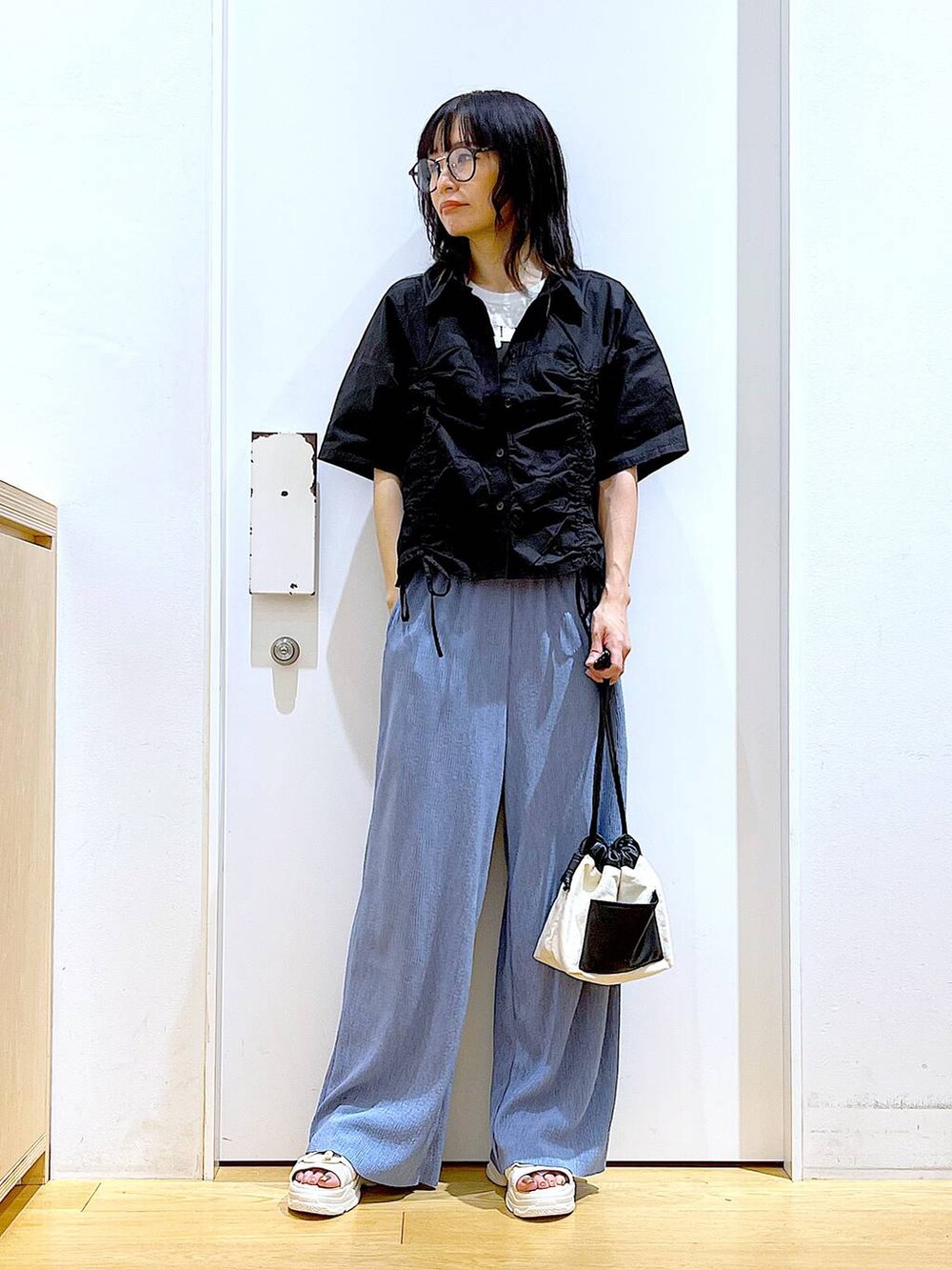 ホワイト系のショルダーバッグ、ホワイト系のサンダル、ブルー系のその他パンツを着用したレディースの春コーディネートの2枚目の写真