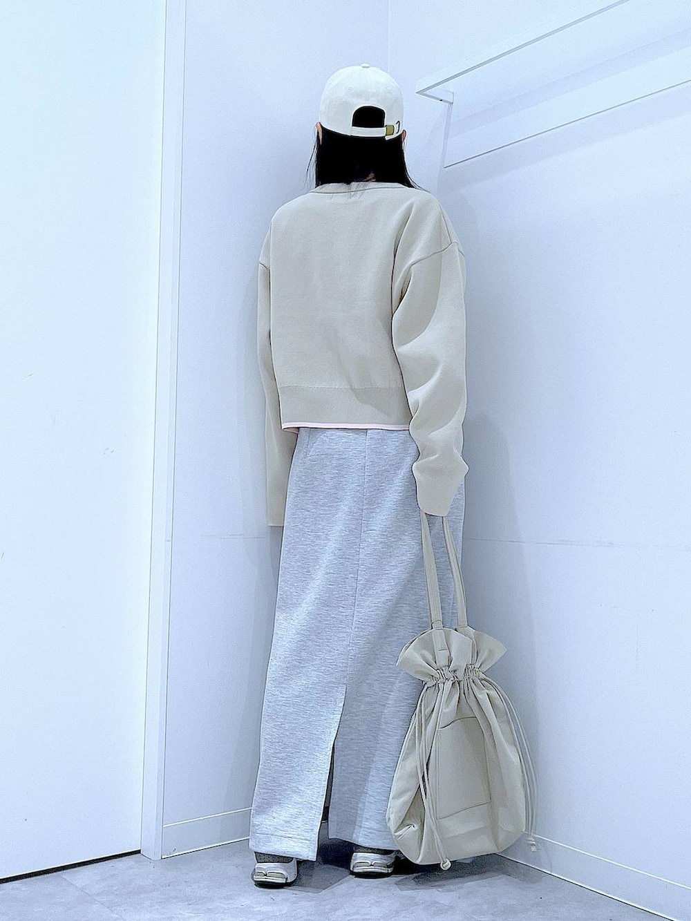 ブラック系のTシャツ/カットソー、ベージュ系のトートバッグ、グレー系のスカートを着用したレディースの冬コーディネートの5枚目の写真