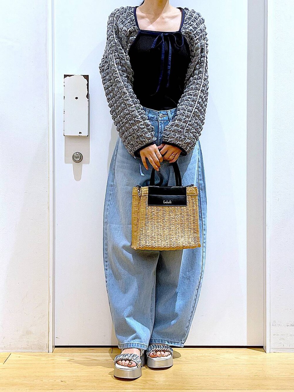 ブルー系のデニムパンツ、ブラック系のTシャツ/カットソー、ベージュ系のショルダーバッグを着用したレディースの夏コーディネートの6枚目の写真