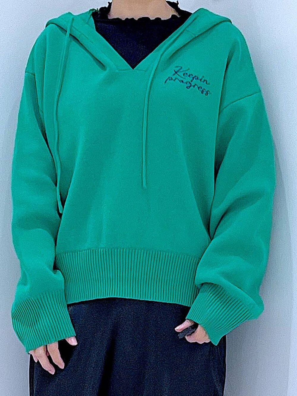 ブラック系のTシャツ/カットソー、ホワイト系のショルダーバッグ、グリーン系のニット/セーターを着用したレディースの春コーディネートの7枚目の写真