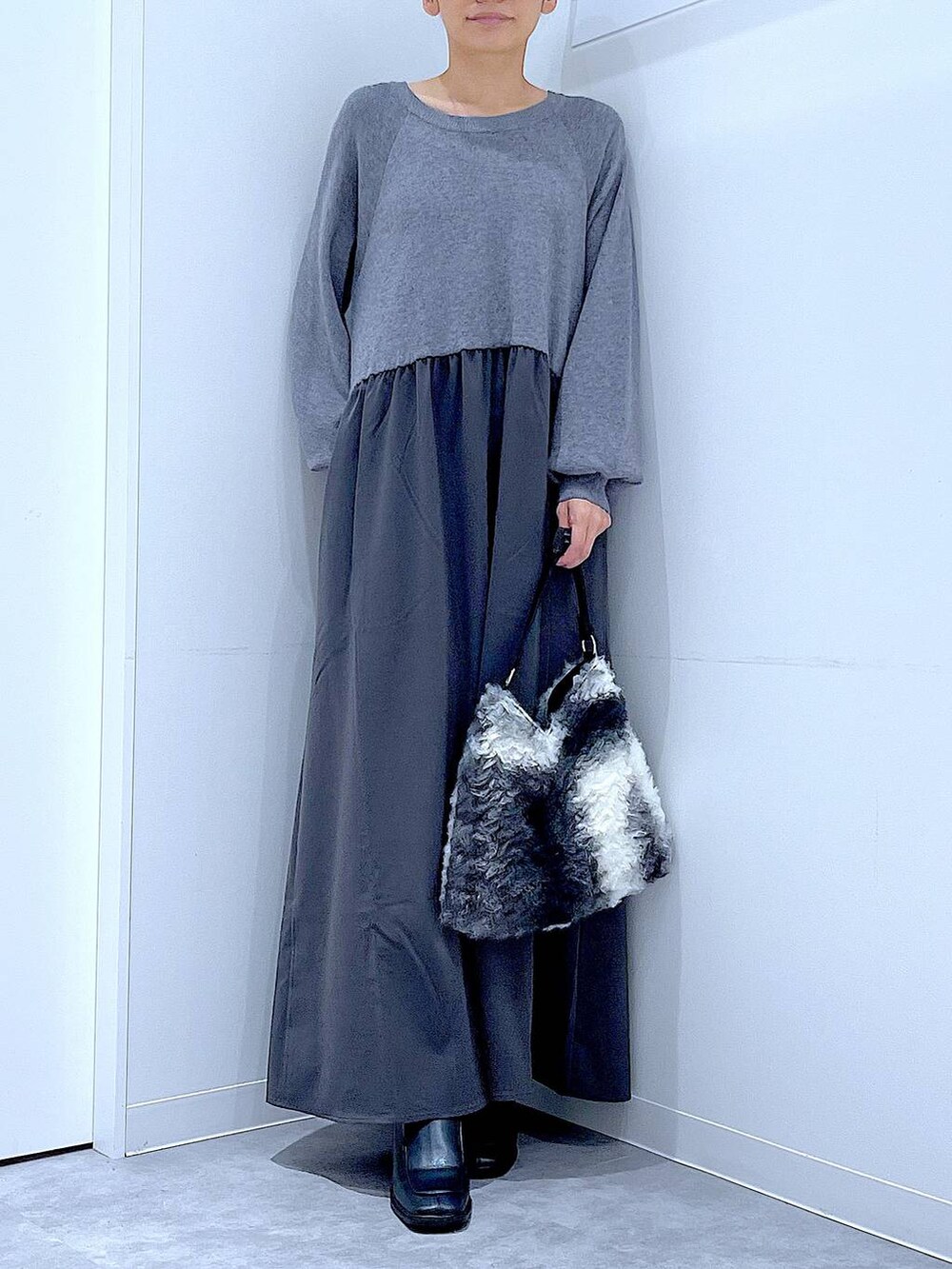 ブラック系のブーツ、ブラック系のショルダーバッグ、グレー系のワンピースを着用したレディースの秋コーディネートの6枚目の写真