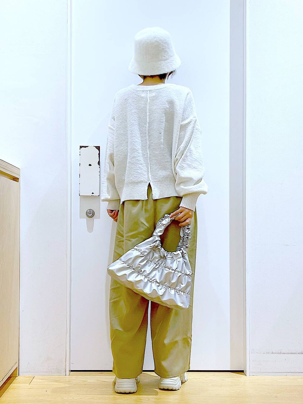 ベージュ系のブーツ、イエロー系のその他パンツ、シルバー系のショルダーバッグを着用したレディースの冬コーディネートの5枚目の写真