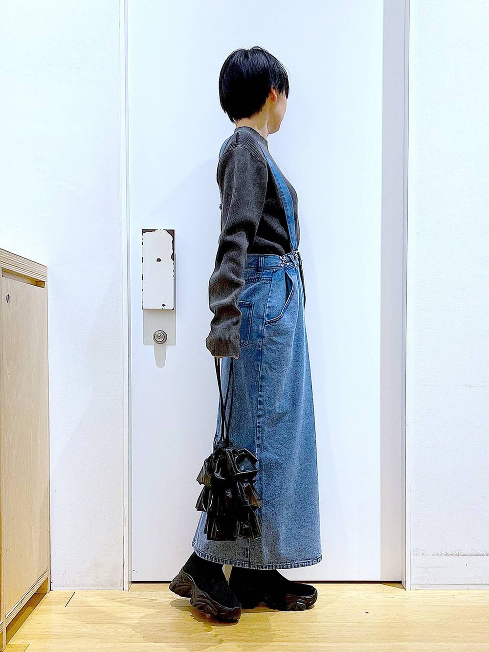 ブラック系のブーツ、ブラック系のショルダーバッグ、ブラック系のニット/セーターを着用したレディースの春コーディネートの4枚目の写真