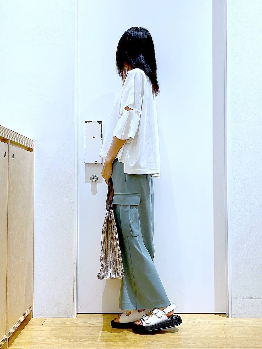 ホワイト系のサンダル、グリーン系のスカート、ブラウン系のトートバッグを着用したレディースの夏コーディネートの3枚目の写真