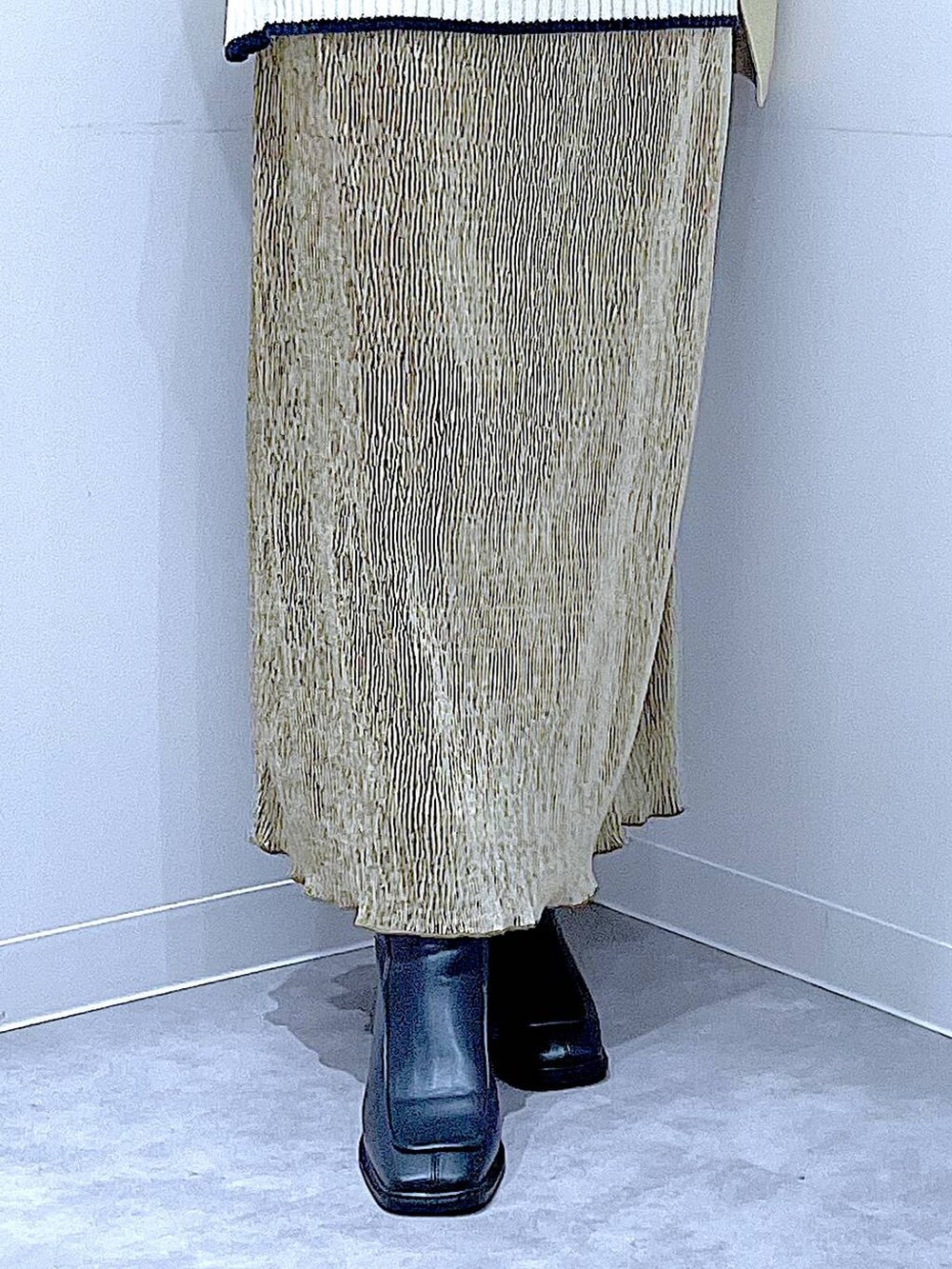 ベージュ系のステンカラーコート、ブラック系のブーツ、ホワイト系のショルダーバッグを着用したレディースの冬コーディネートの8枚目の写真