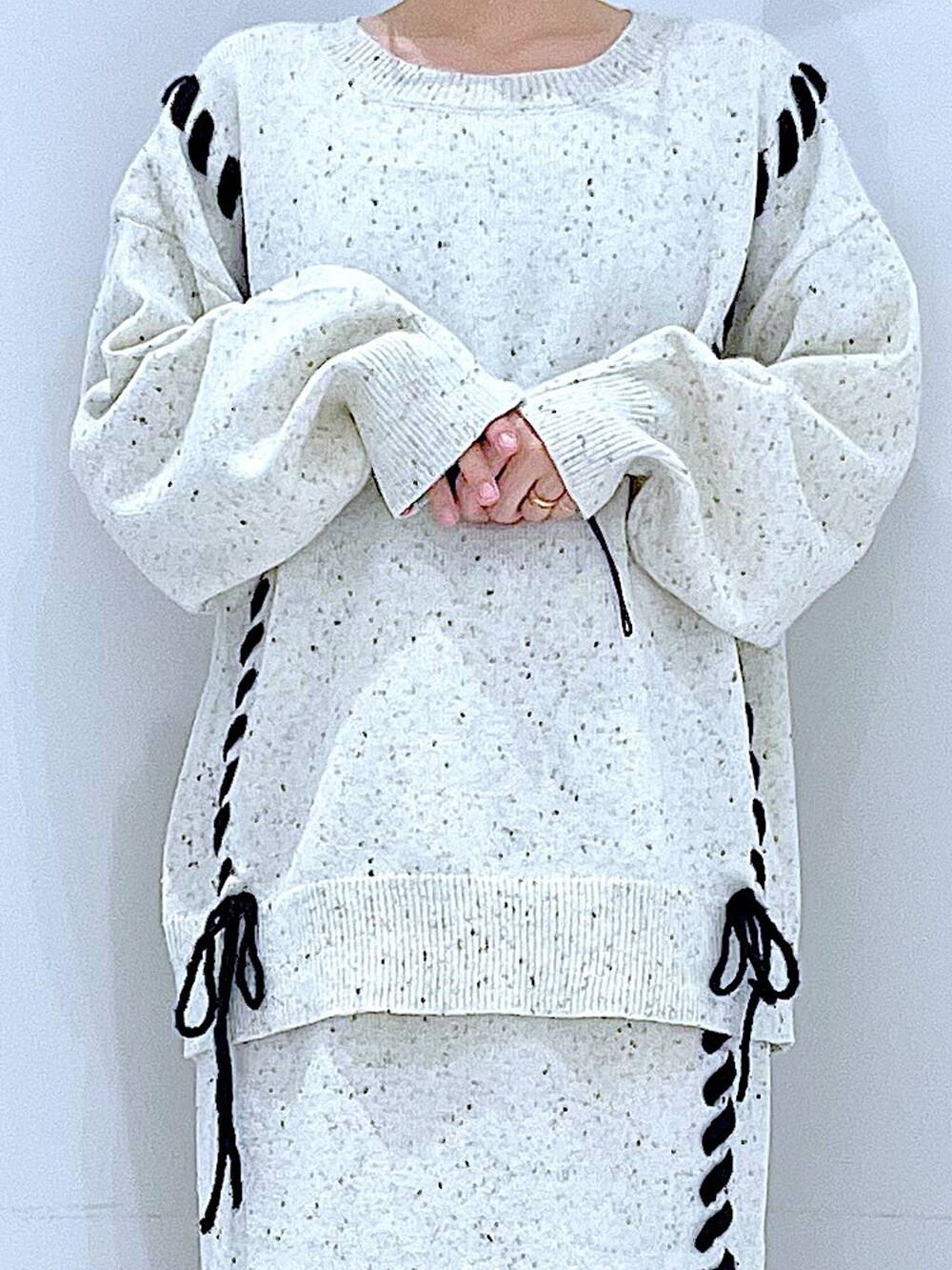 ブルー系のショルダーバッグ、ホワイト系のニット/セーター、ベージュ系のスカートを着用したレディースの秋コーディネートの7枚目の写真