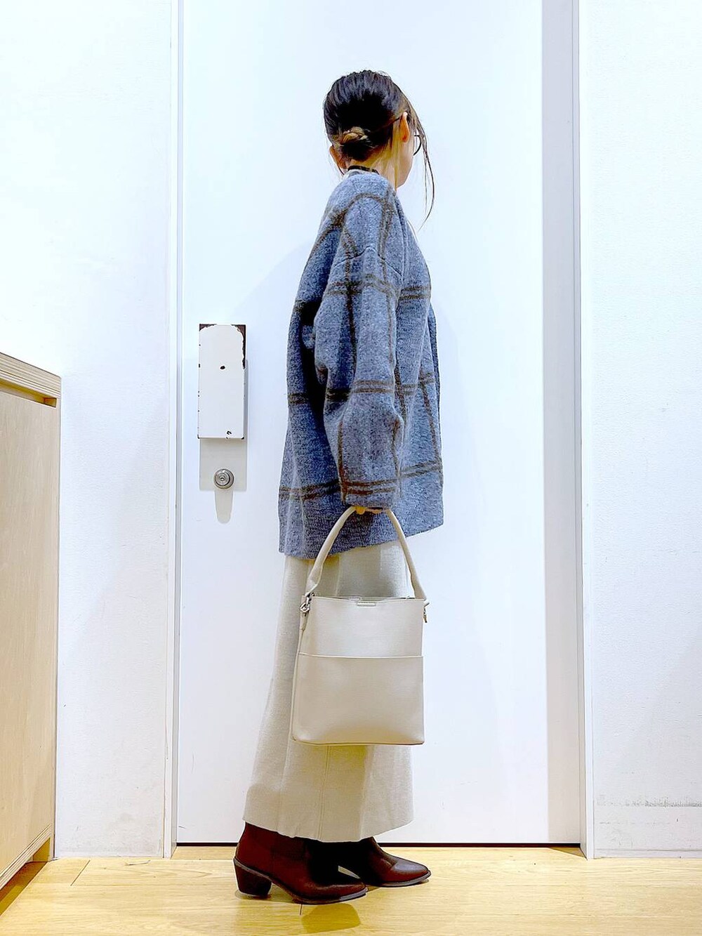 ブルー系のカーディガン/ボレロ、グレー系のショルダーバッグ、グレー系のスカートを着用したレディースの冬コーディネートの4枚目の写真