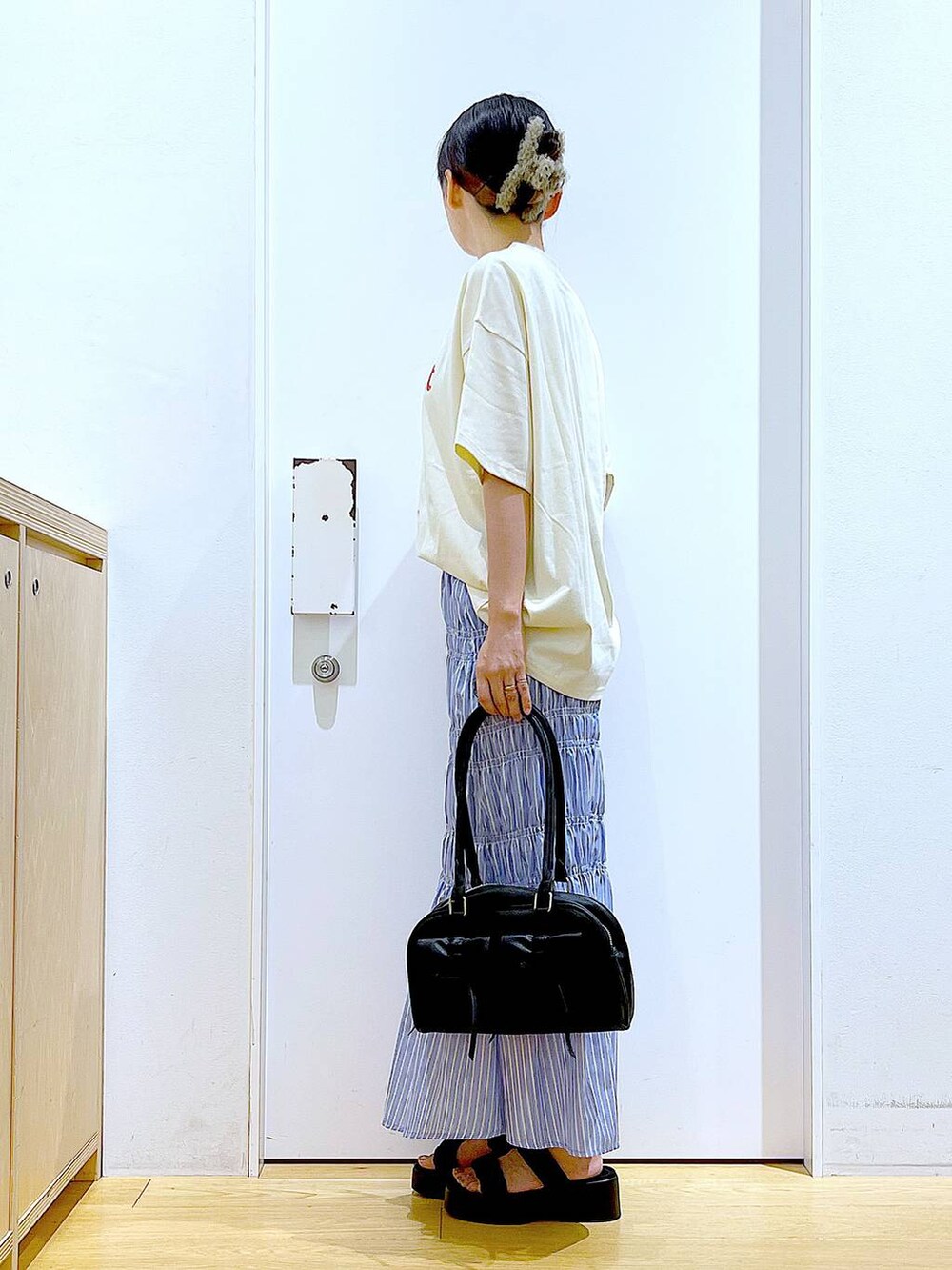 ブラック系のサンダル、その他のスカート、ブラック系のハンドバッグを着用したレディースの夏コーディネートの3枚目の写真