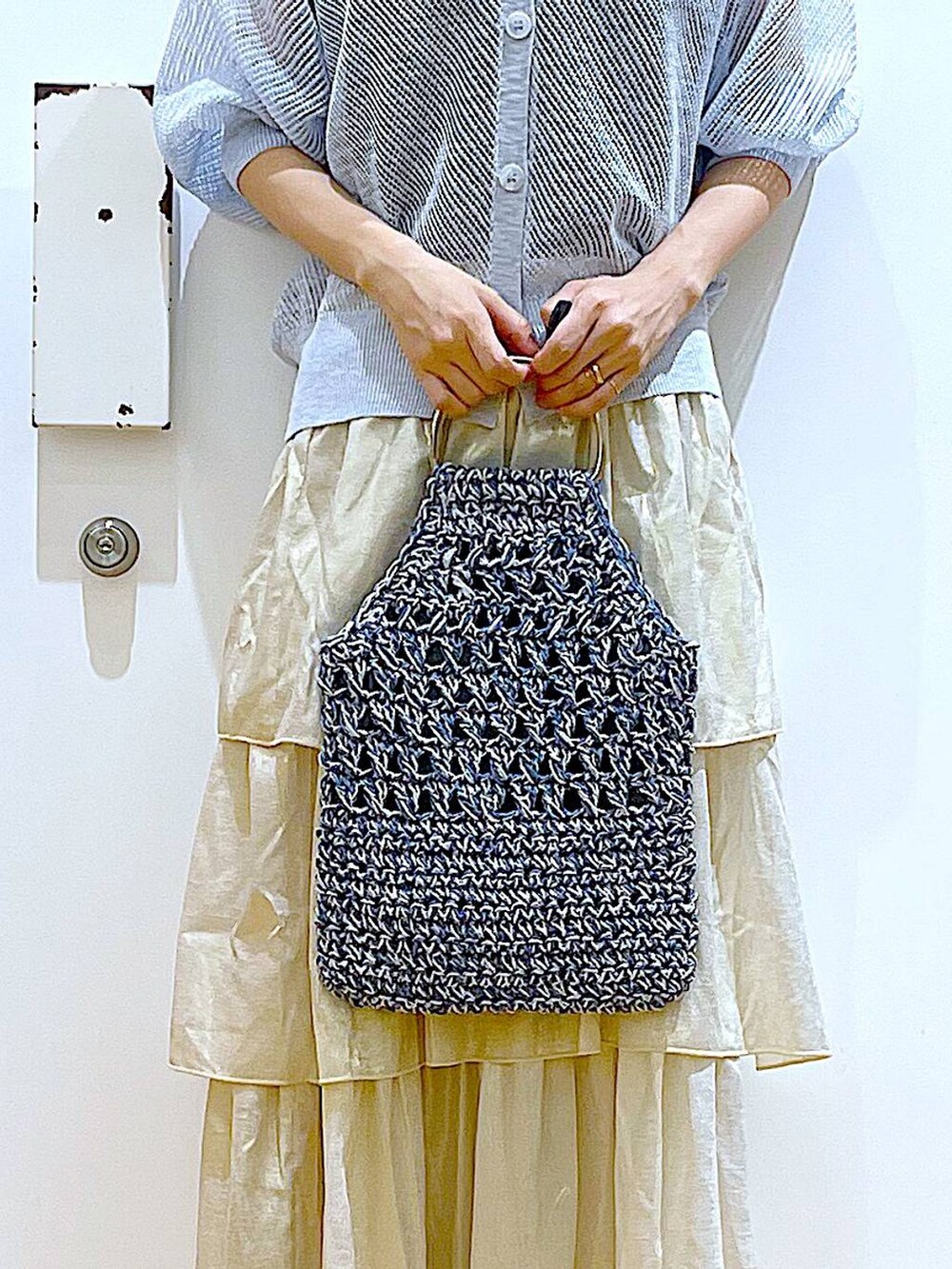 シルバー系のサンダル、ブルー系のハンドバッグ、ゴールド系のスカートを着用したレディースの夏コーディネートの9枚目の写真